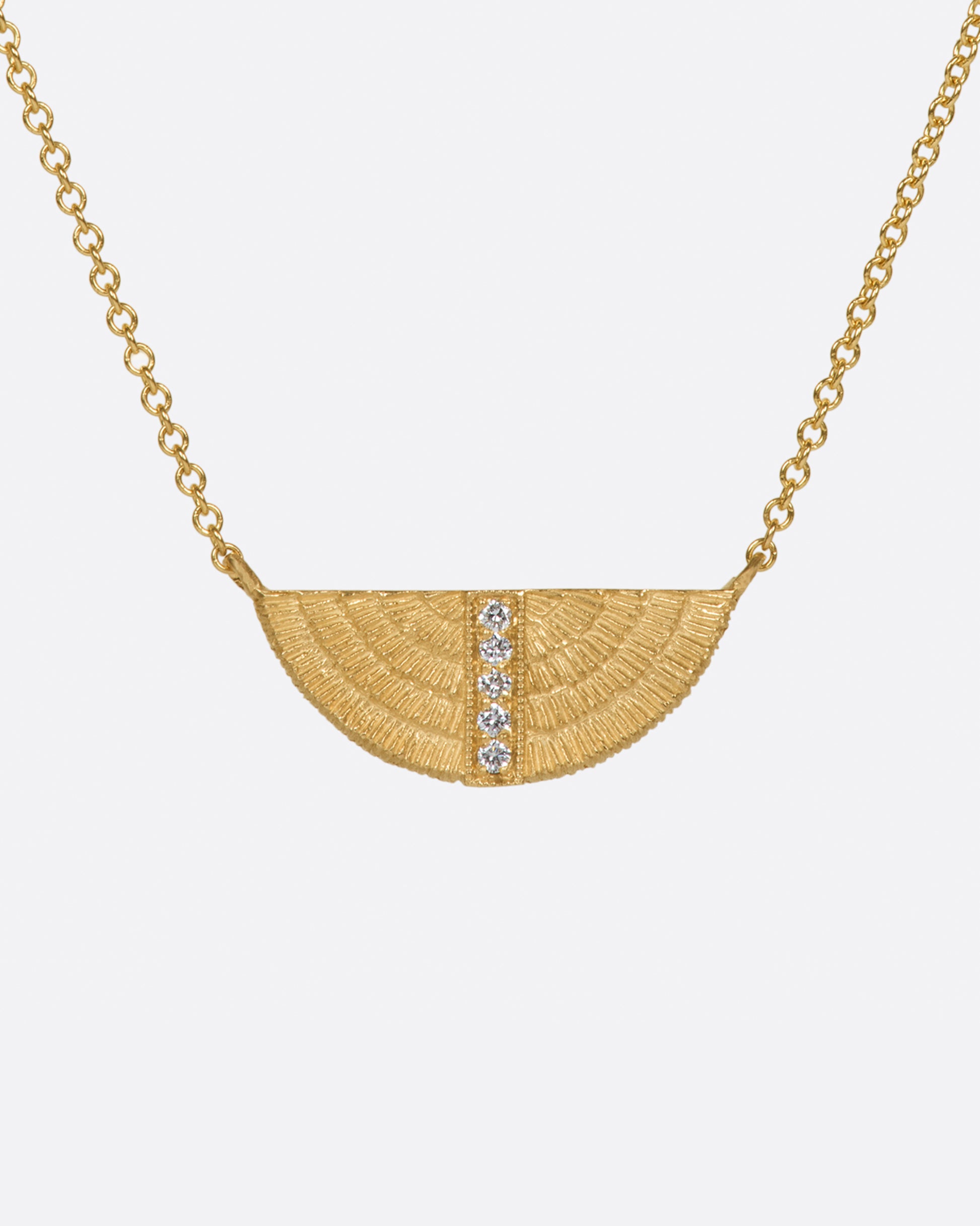 A semi-circular, textured pendant with a row of white diamonds.