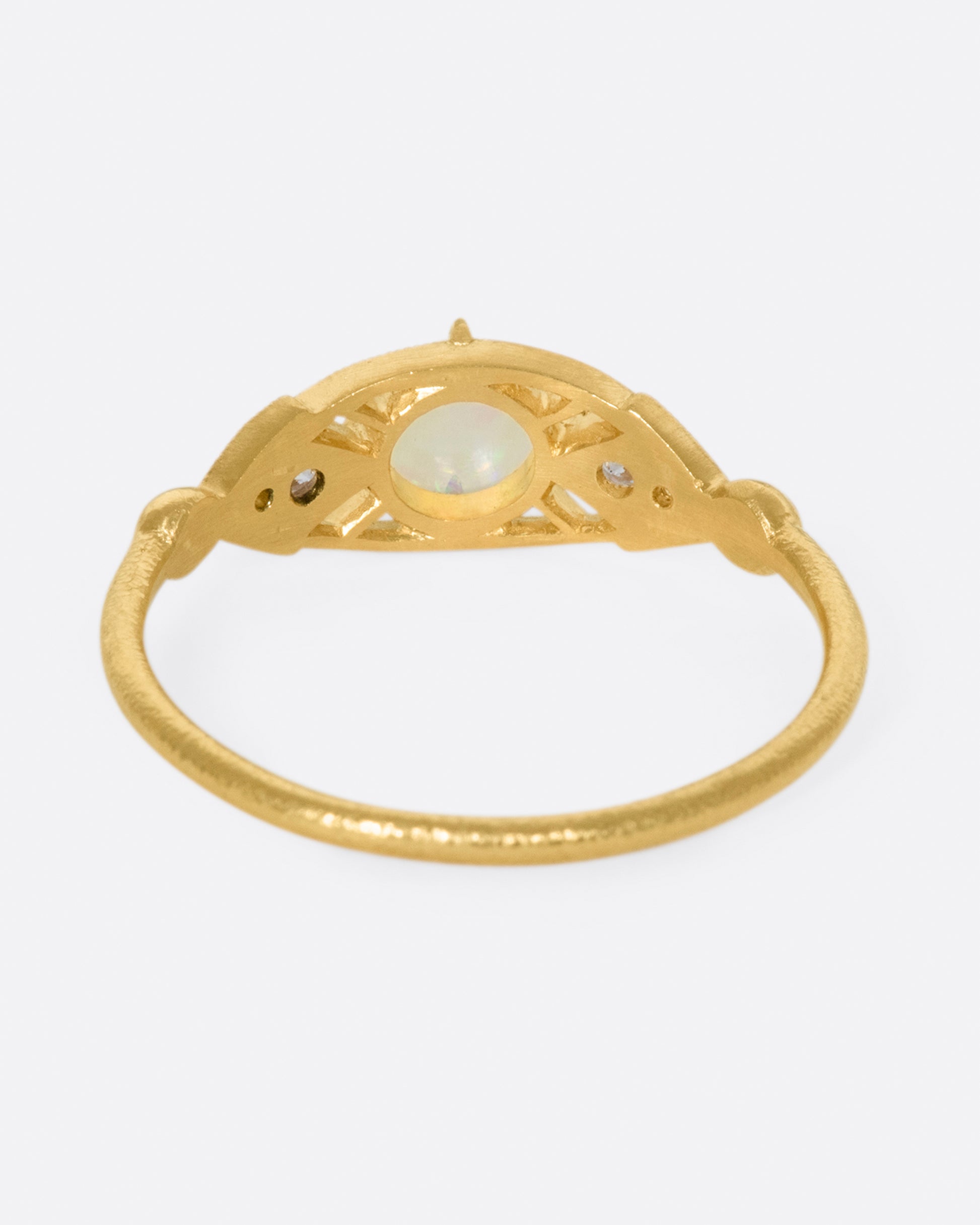 A glowy opal flanked with tiny, sparkly, diamonds, and set on a delicate band 14k gold band