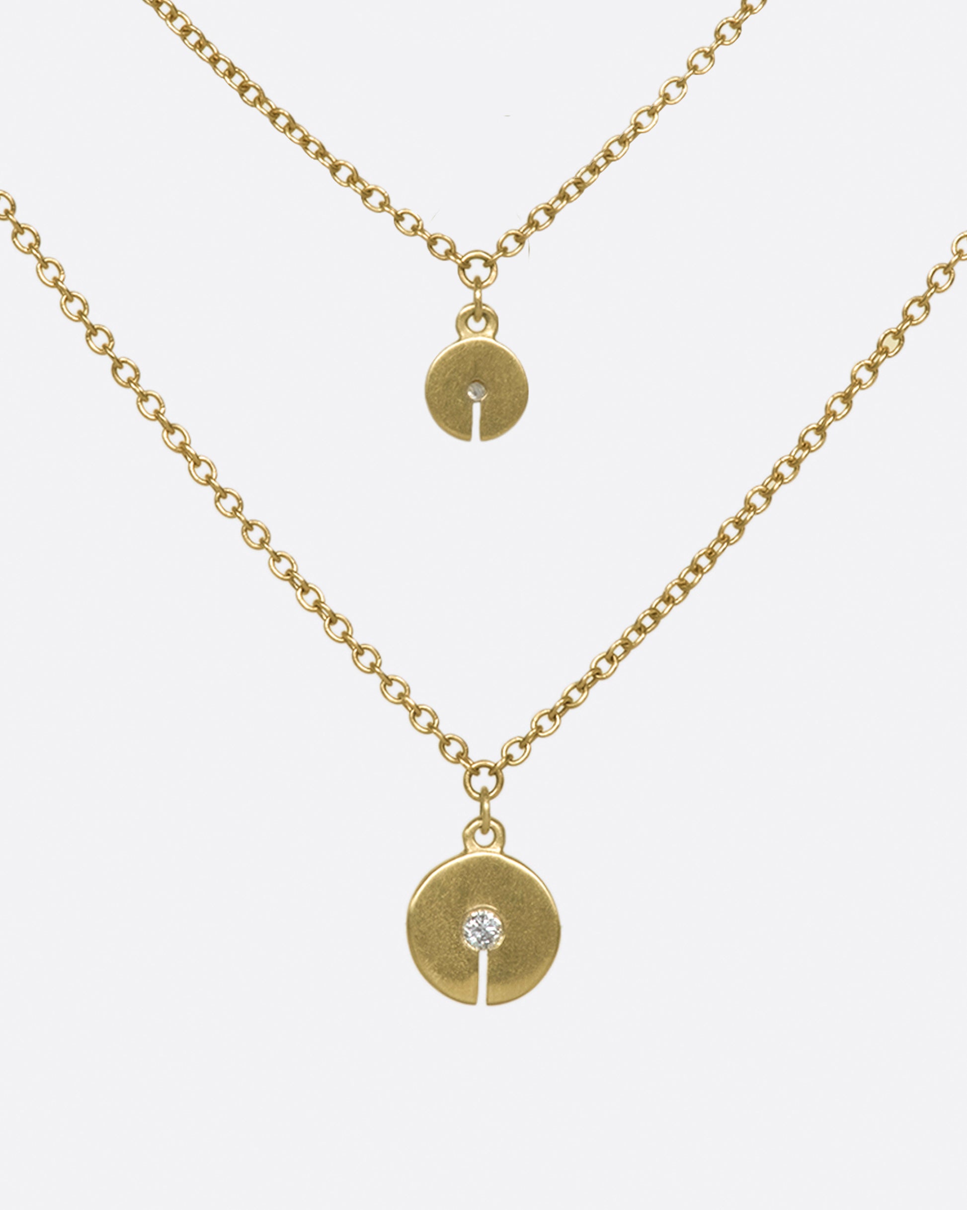 A double-layer 10K gold necklace with two grey diamond discs that elegantly dot your neck.
