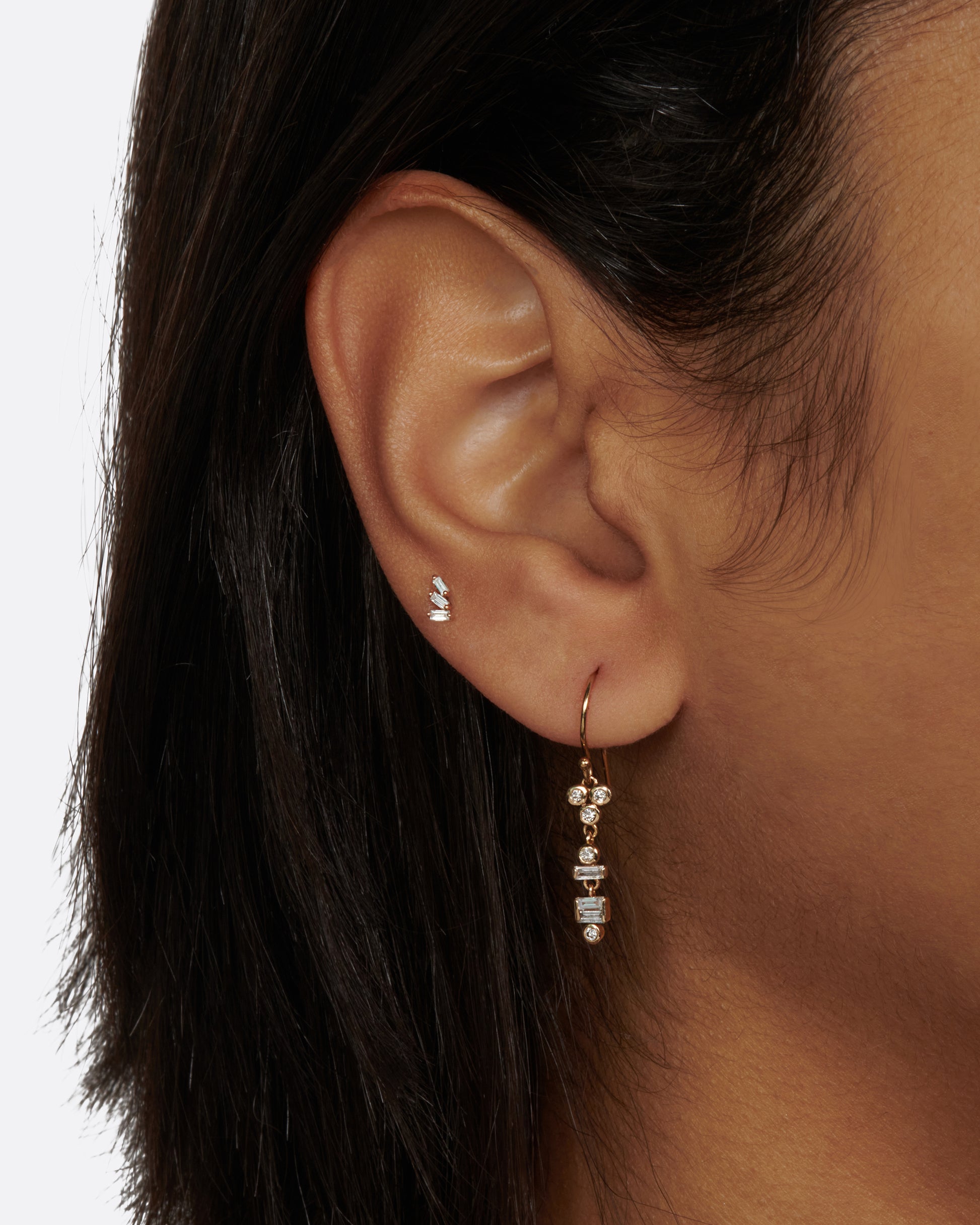 A pair of diamond totem drop earrings with layers of round and diamond baguettes.