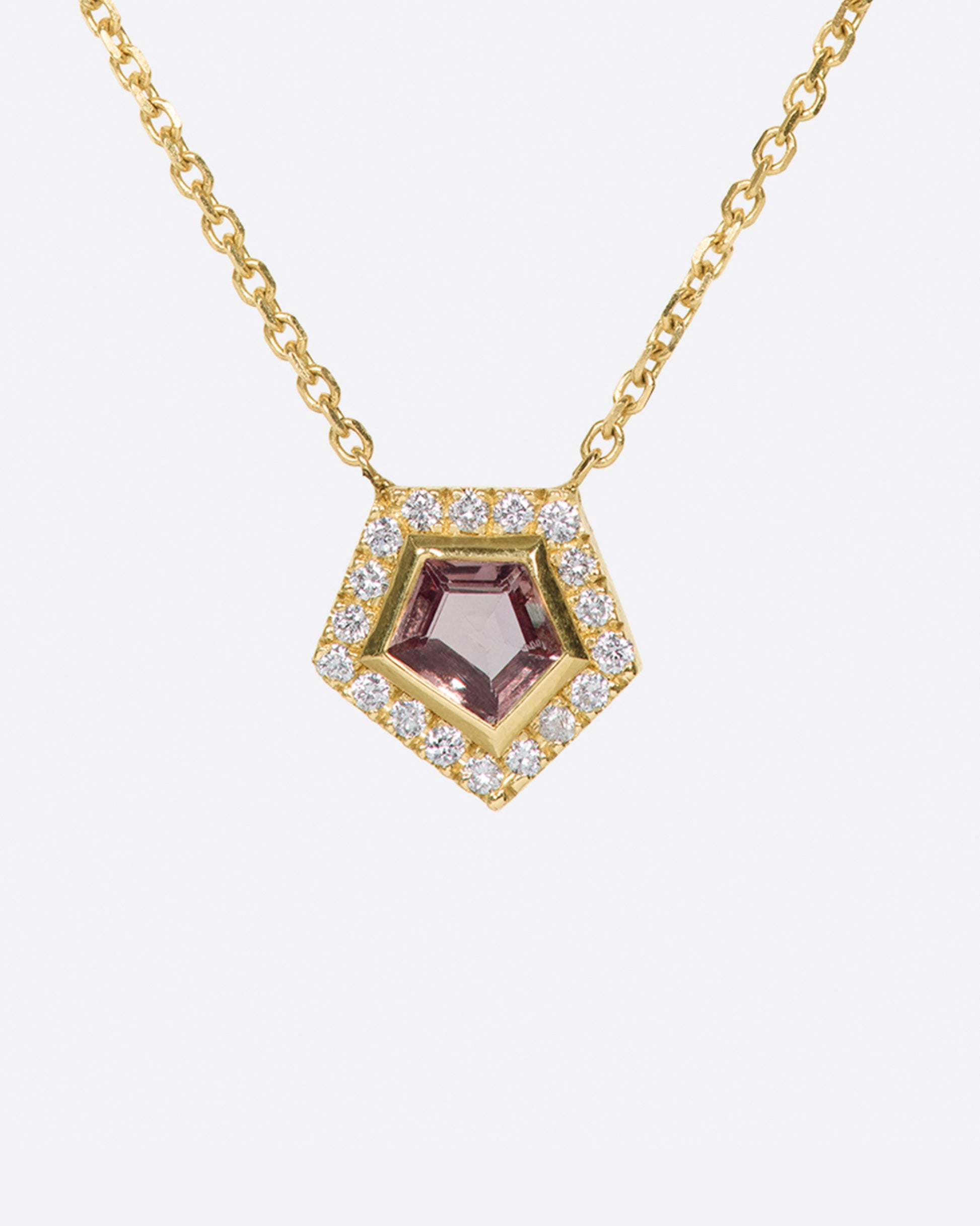 A shield shaped pink sapphire pendant necklace with a diamond halo.