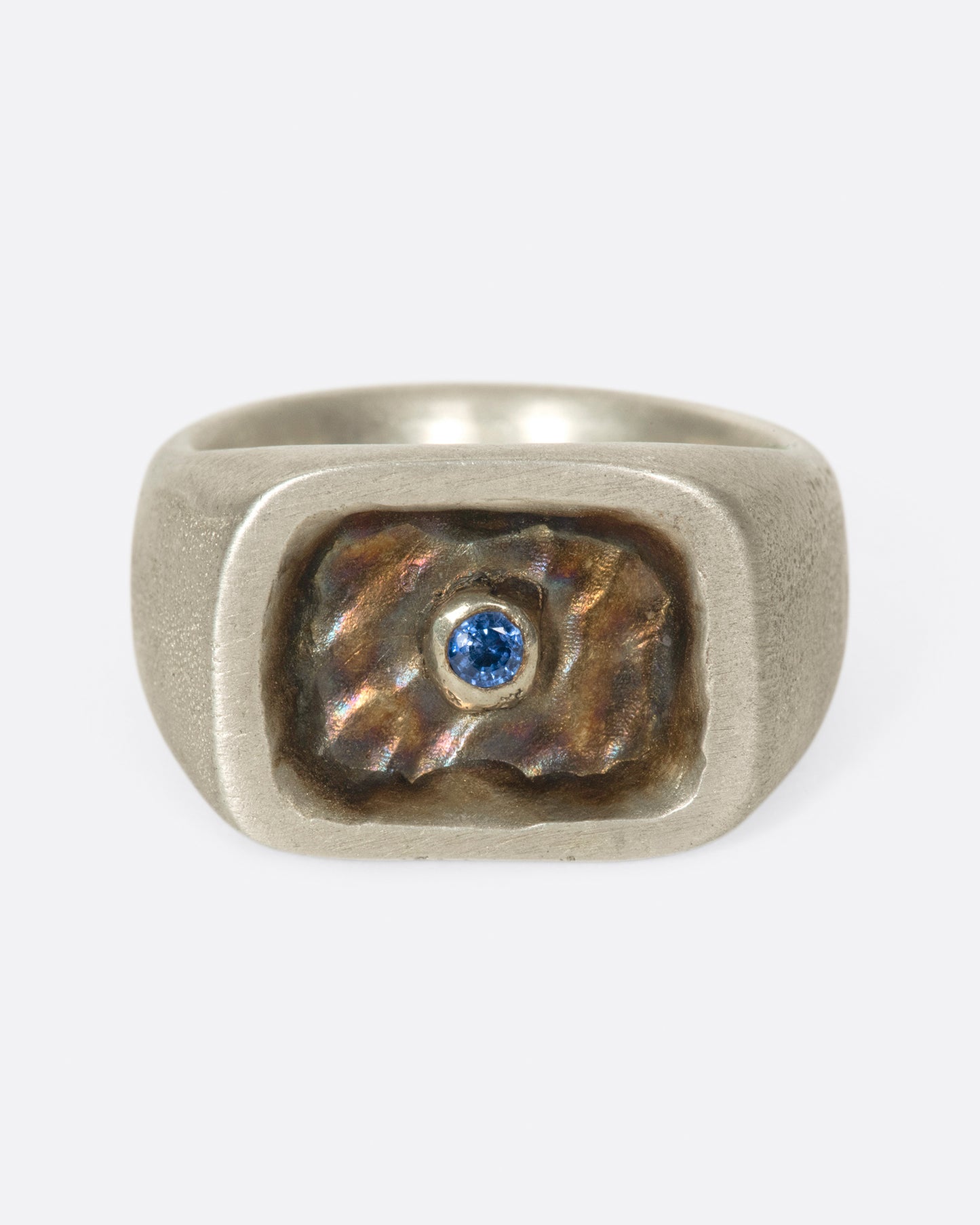 A solid, hand carved signet ring with gold plating and a royal blue sapphire.