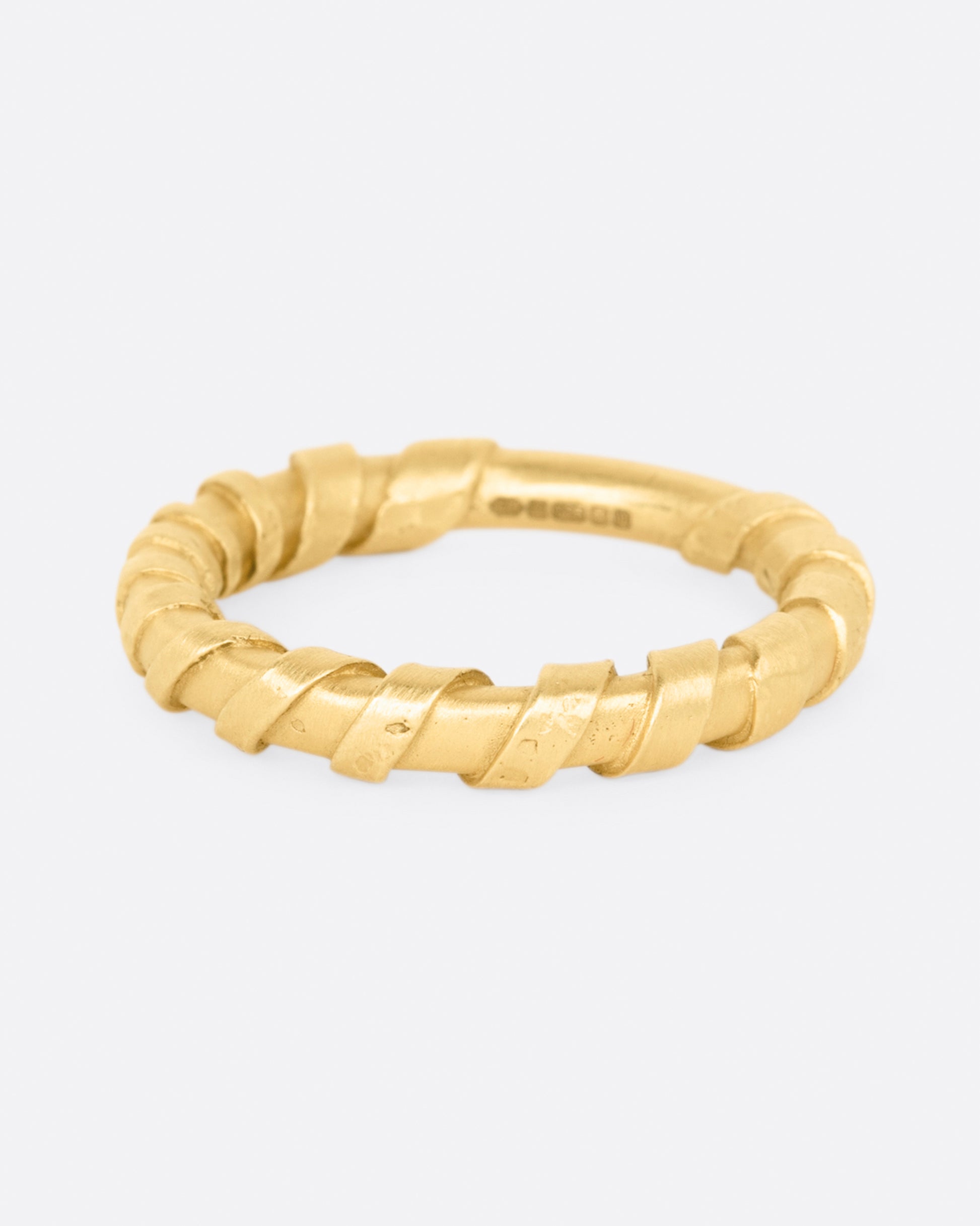 A rounded band, wrapped in a flat stripe of gold.