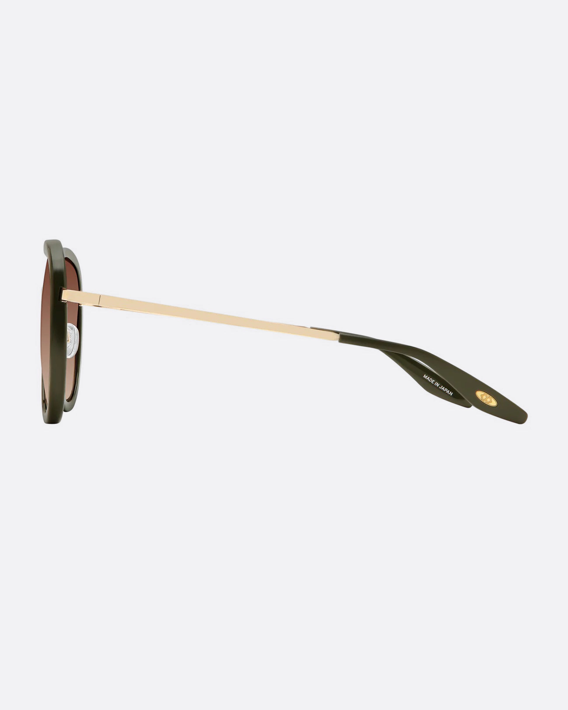 A pair of aviator sunglasses with green frames and  an inlaid titanium bridge. The lenses are a brown gradient. Shown from the side.