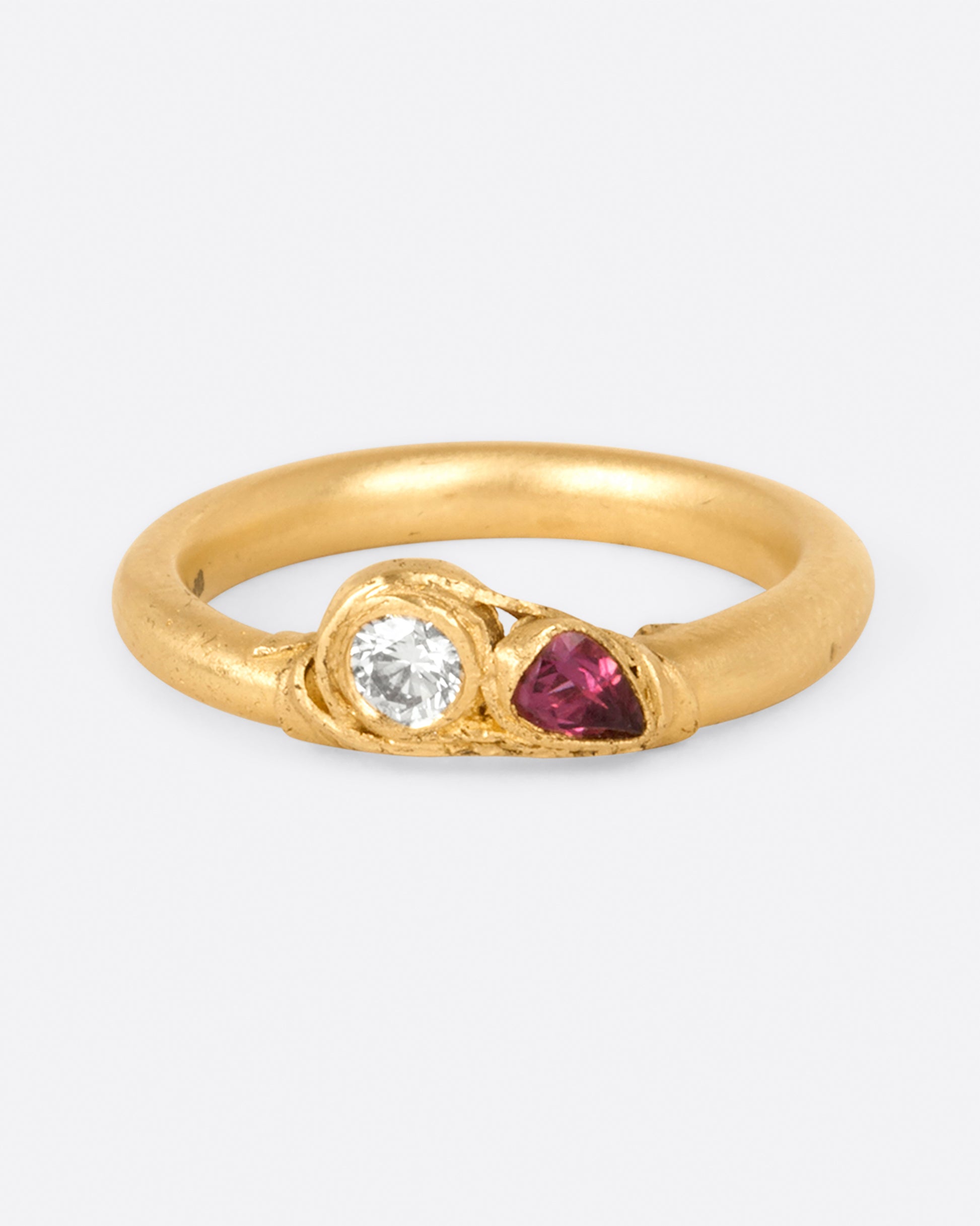 A round white diamond and a faceted ruby are held in place by one of Fraser Hamilton's signature wrapped settings.