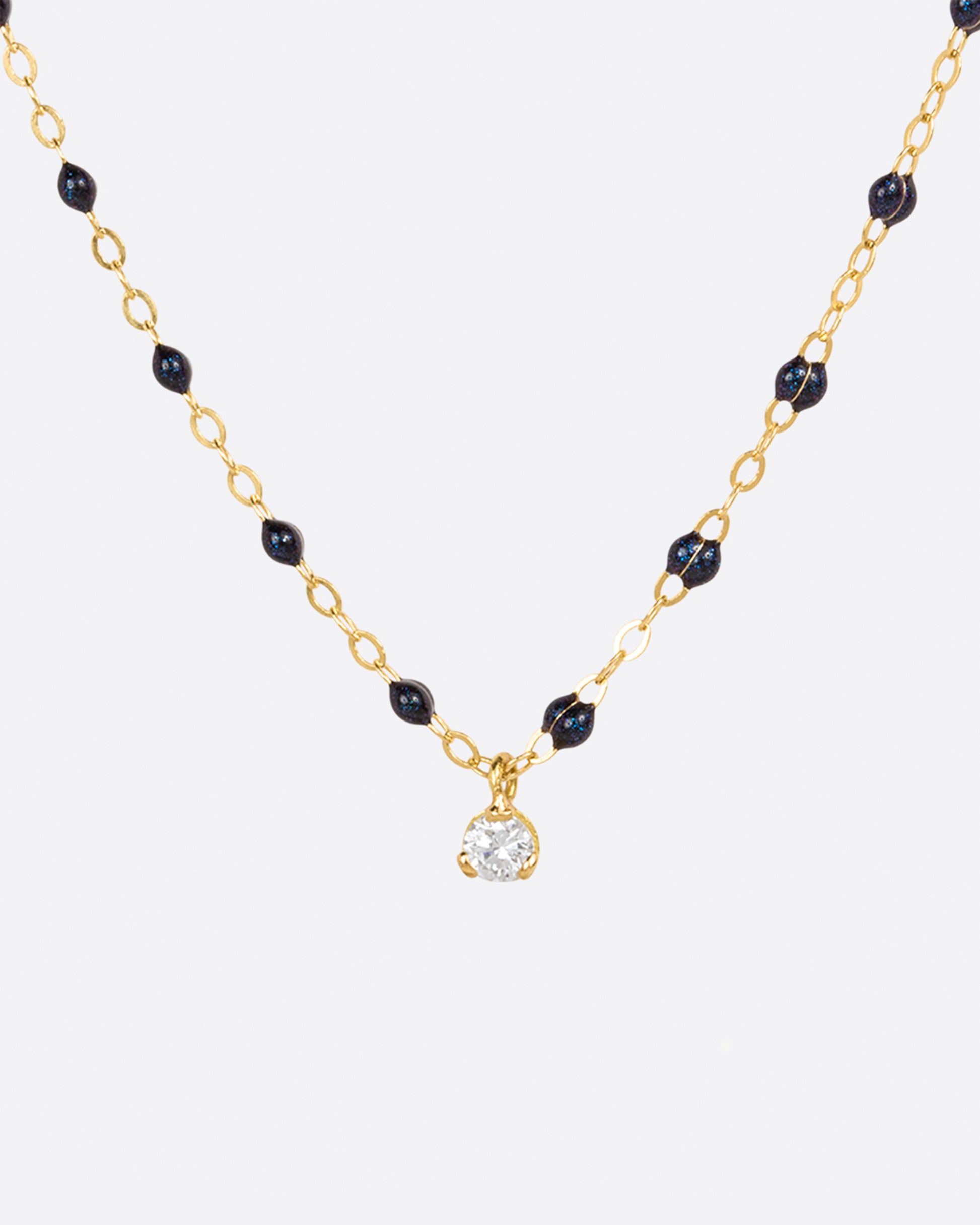 A classic Gigi Clozeau necklace with midnight blue resin beads and a single diamond charm.