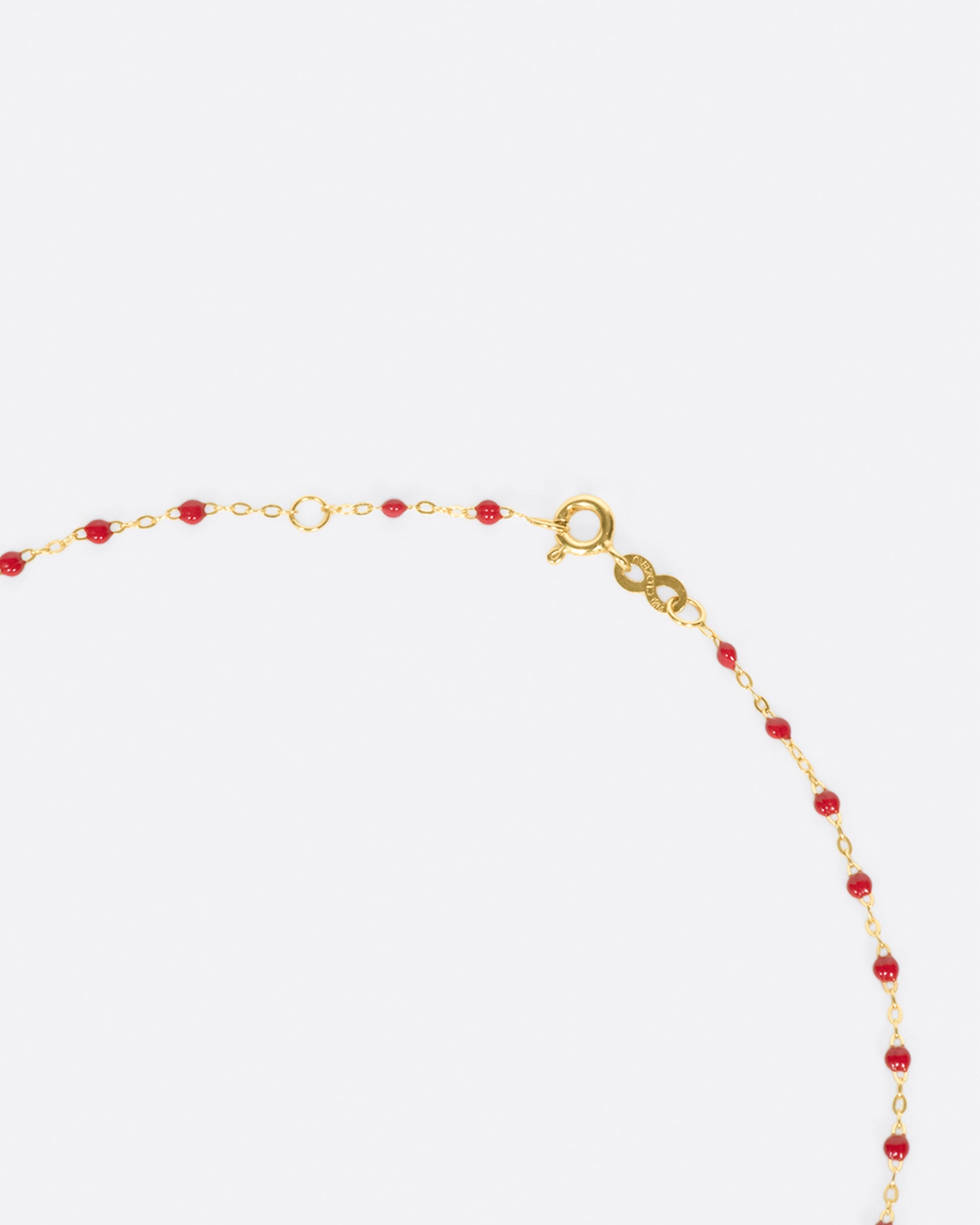 A thin yellow gold chain necklace with resin beads. Each necklace is hand dipped in melted resin to create the beaded effect. 