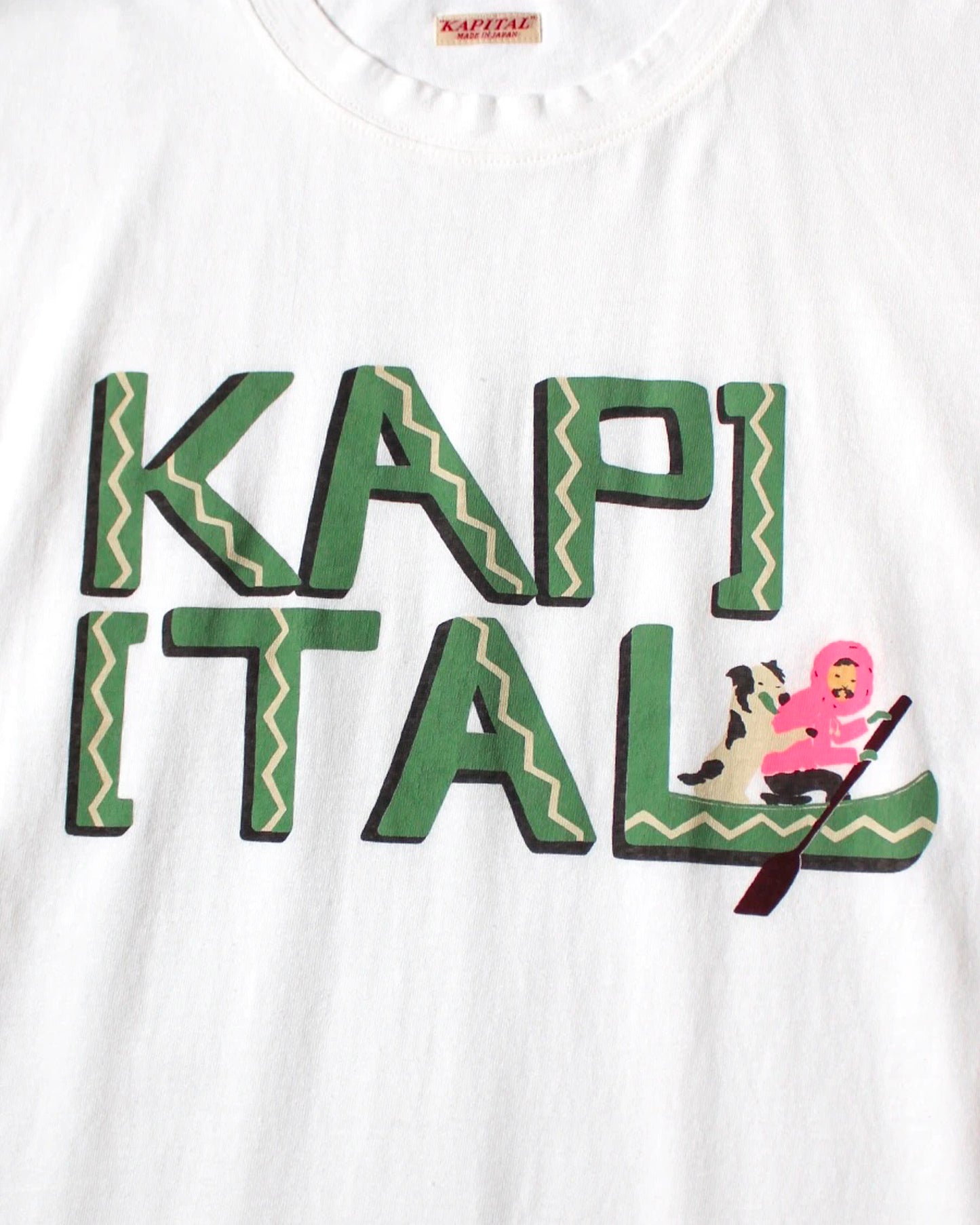 A white t-shirt with hand-drawn lettering reading 'Kapital' and a canoe graphic, shown from the front.