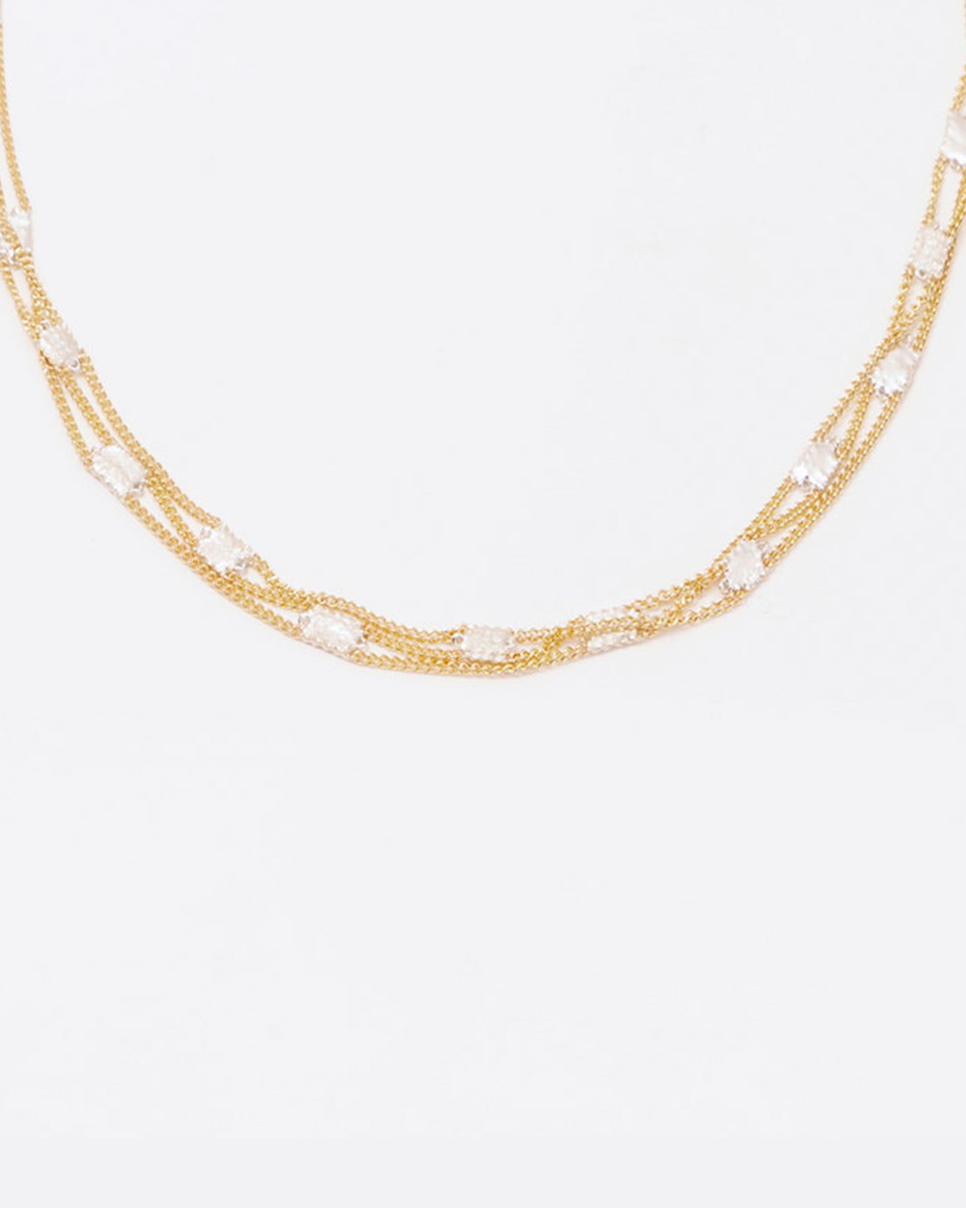 A necklace composed of three solid 18k yellow gold chains connected with sterling silver squares