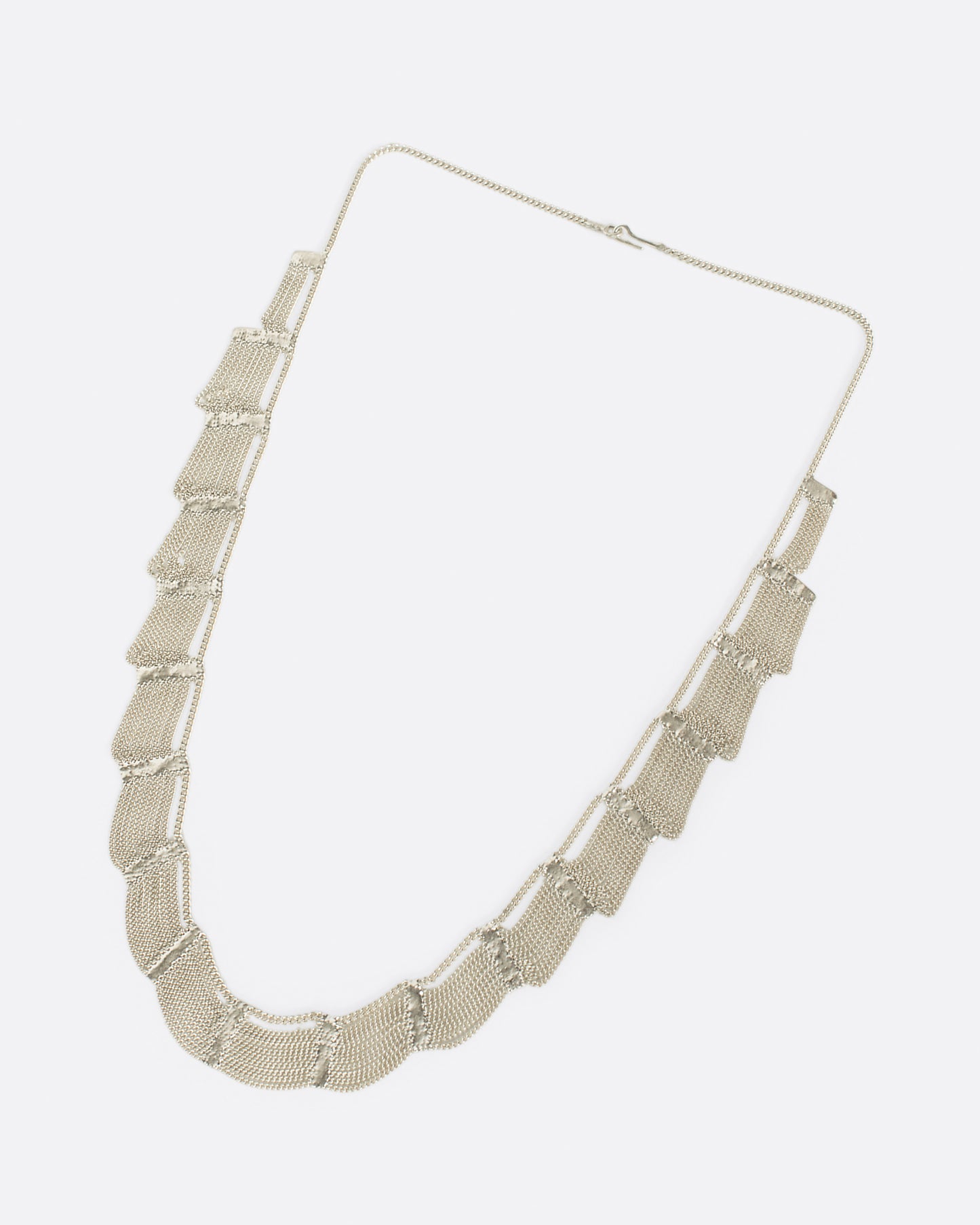 A sterling silver, fringy necklace with silver soldered sections to create a scalloped effect.