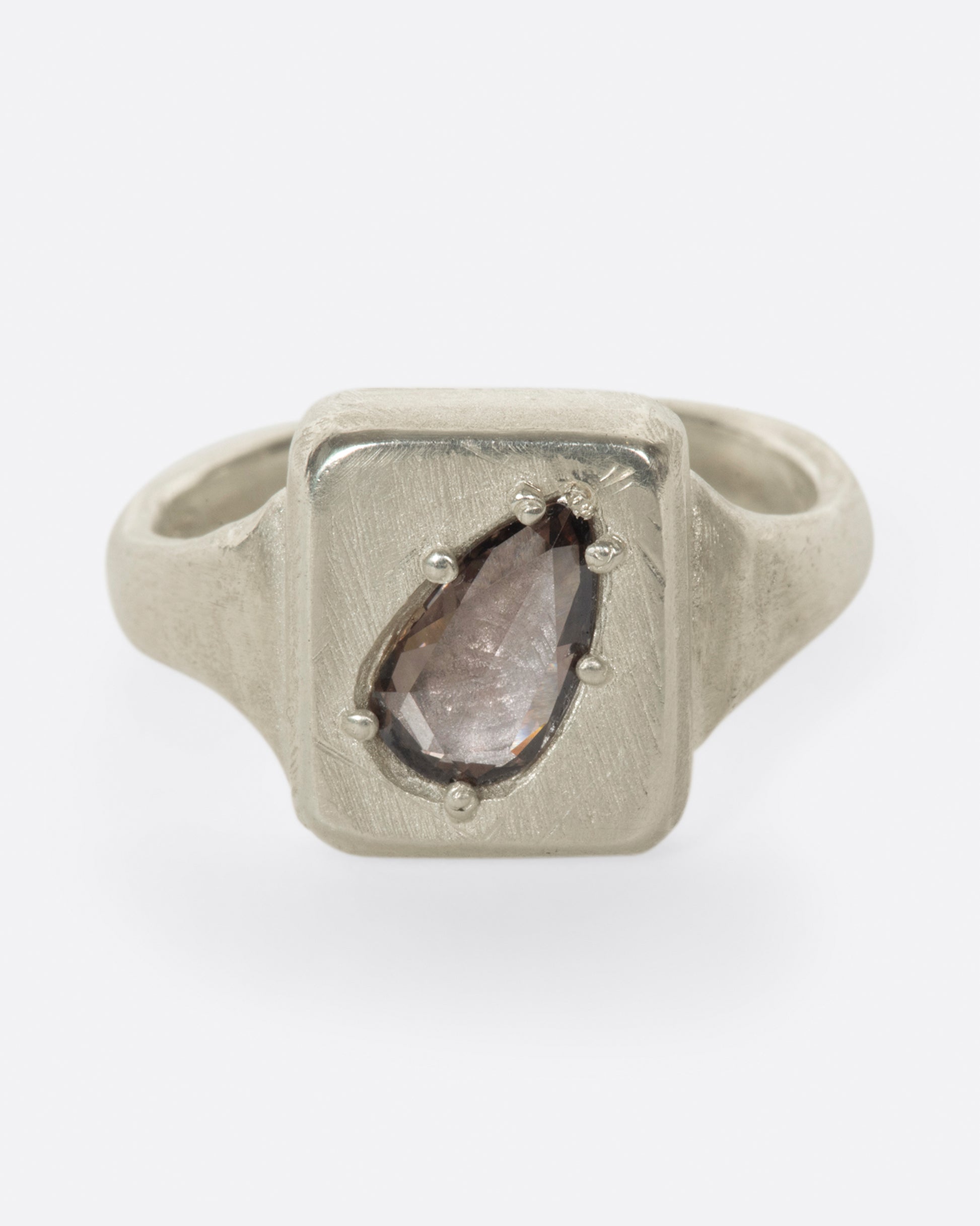 A handmade square signet ring with a cognac diamond sunken into it.
