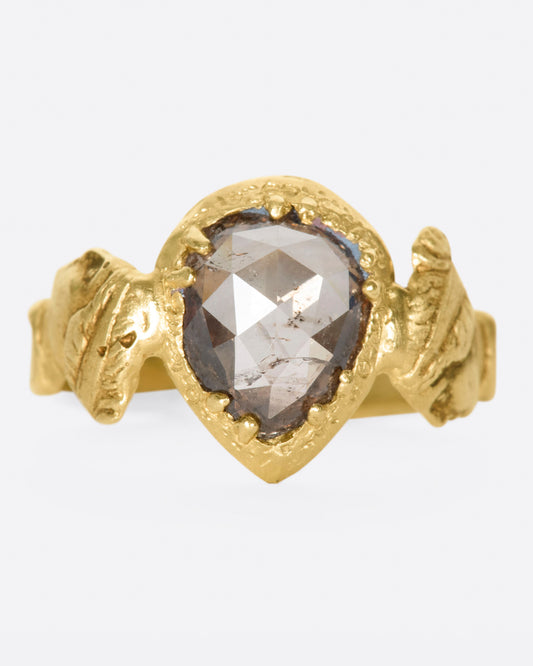 This moody pear-shaped cognac diamond, swirling with chocolaty hues, in an open-back setting that invites light to reflect intensely. The hand-carved bezel and band give a deeply storied feel as if this were dug up in the desert—treasure left behind by an ancient Roman civilization.