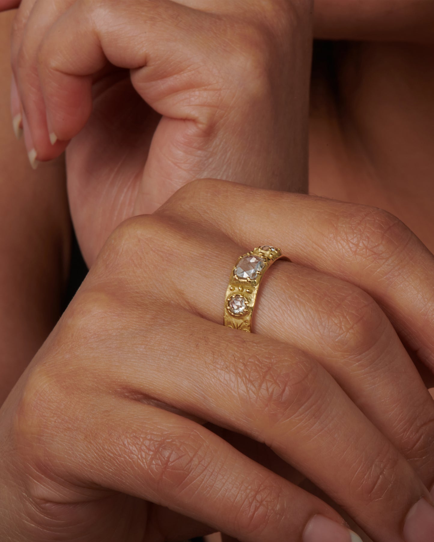 This thoughtfully detailed band has a sparkly rose-cut oval diamond in the center and rose-cut round diamonds on either side