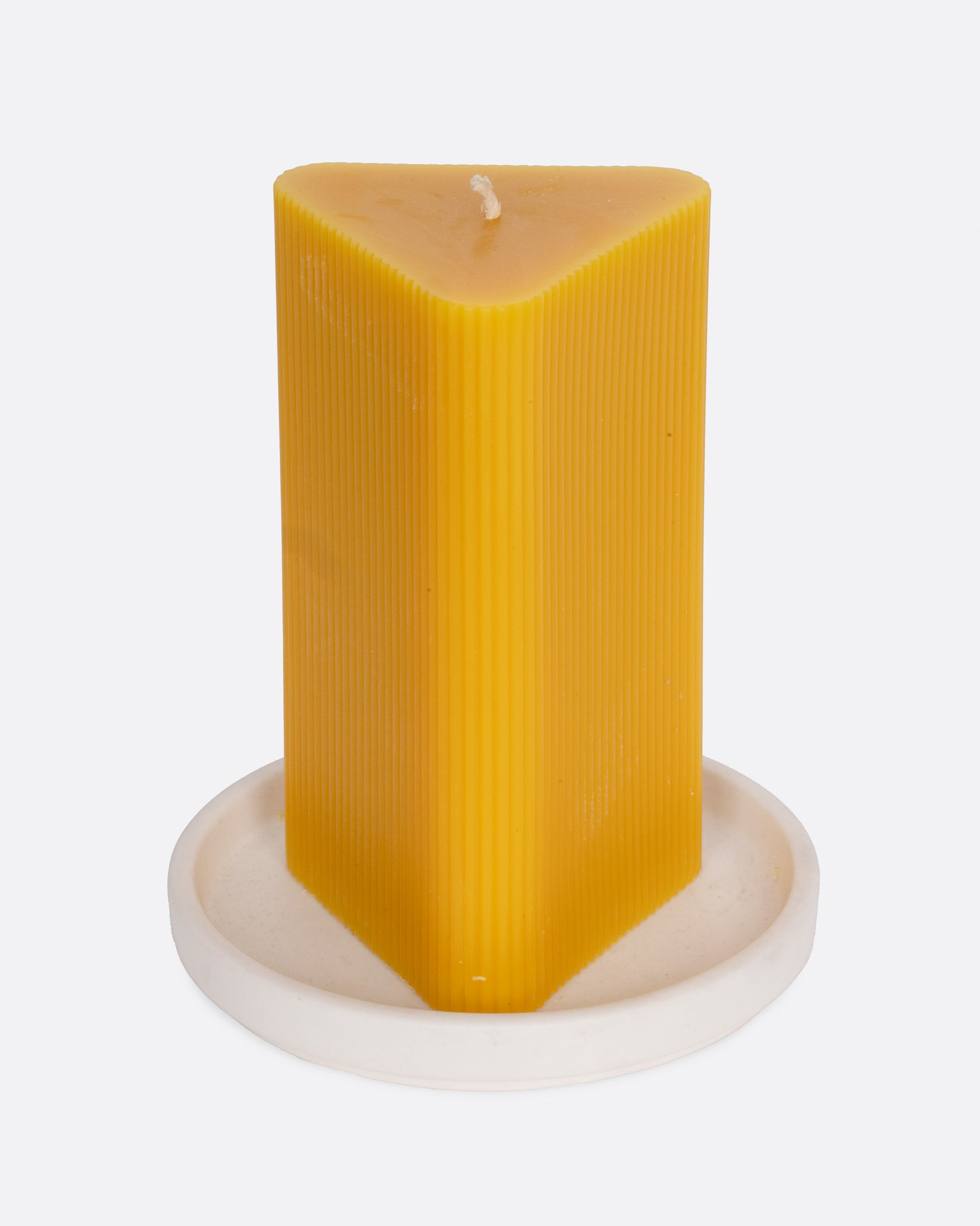 A triangular yellow candle on a white circular base, shown from the front.