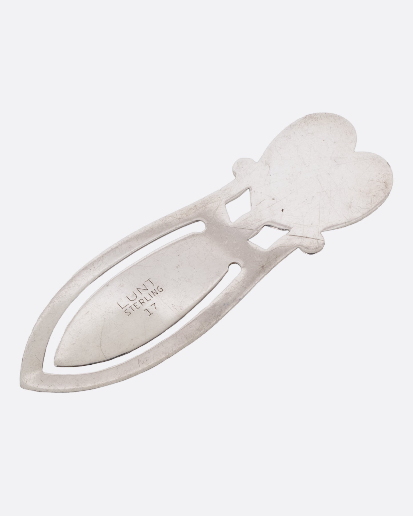 A silver heart shaped bookmark. Shown from the back, lying flat.
