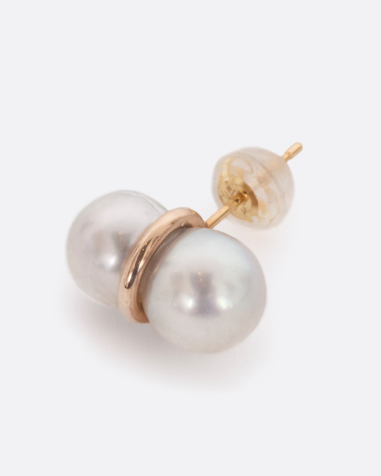 A lovely white pearl is lassoed by a rich, yellow gold loop. Classically minimalist meets modern and unique... a very versatile stud earring. View from the front.