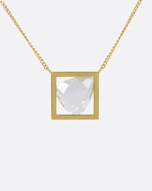 A triangular rose cut diamond in a square gold frame.