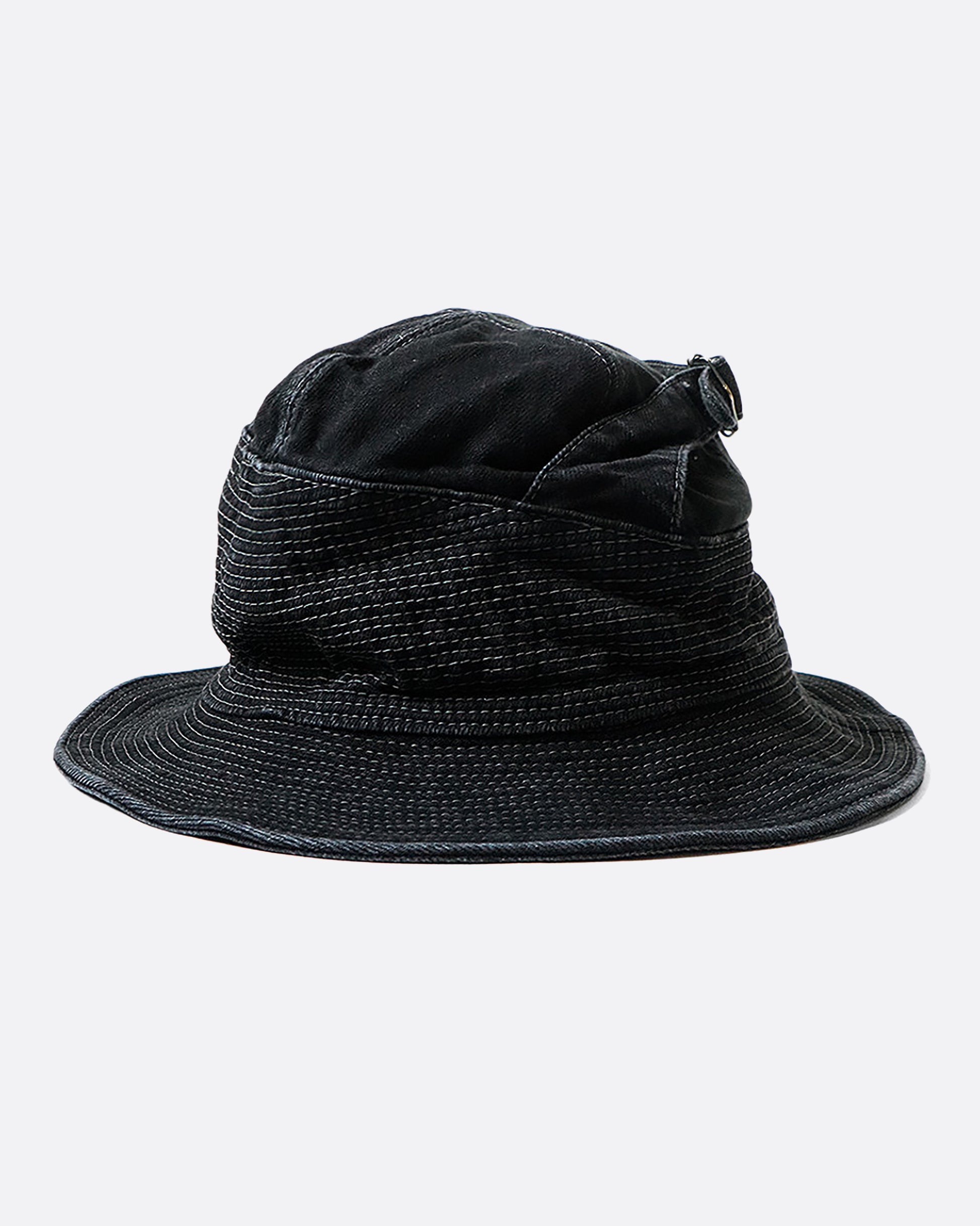 A black denim bucket hat with a buckle at the crown and contrast stitching throughout. View from the side.