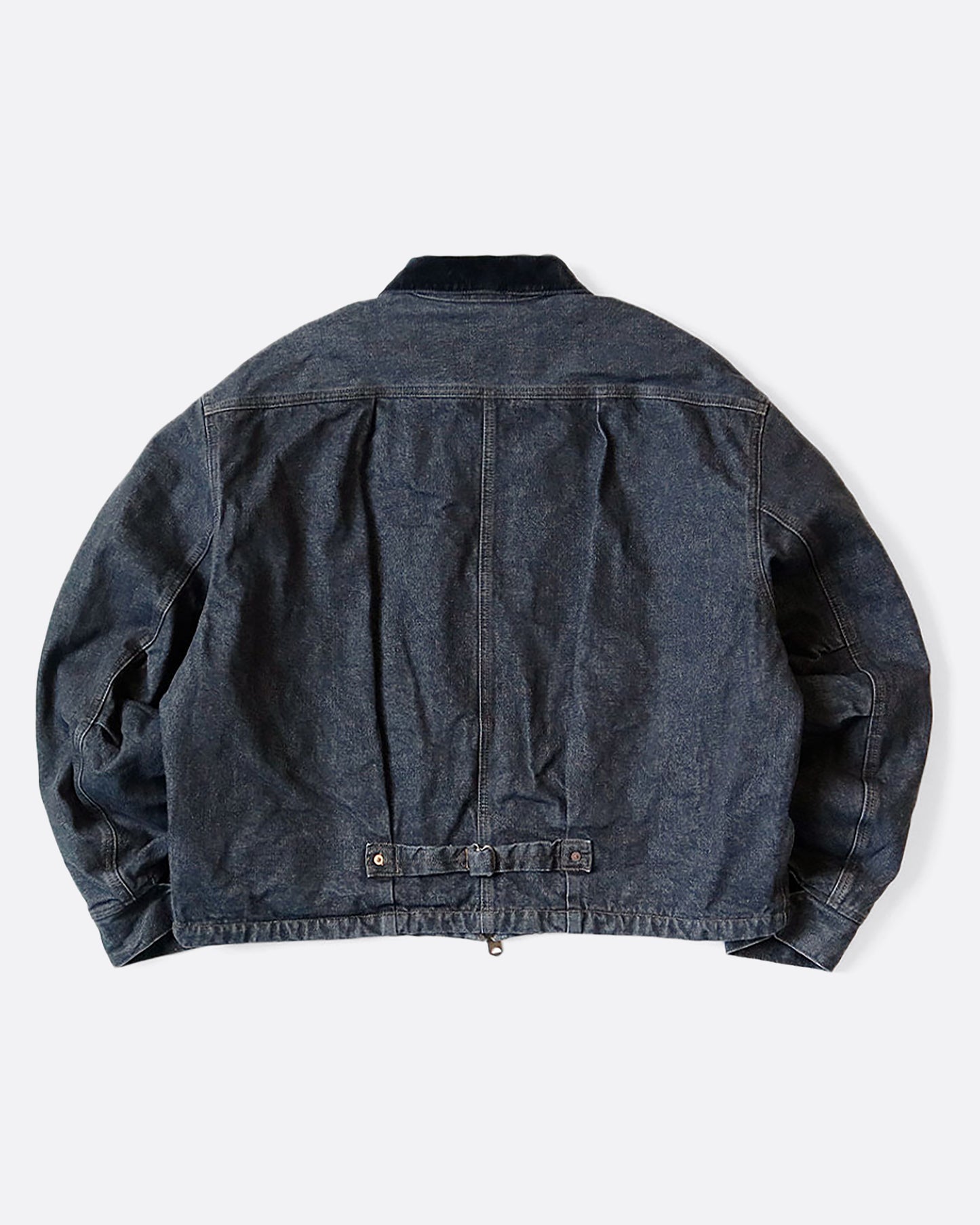 A dark blue denim bomber jacket with a corduroy collar and two front pockets. View of the back, showing buckle at the lower back.