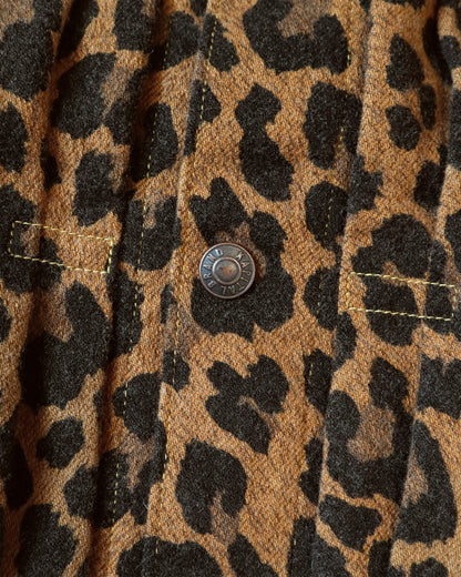 A close up of a leopard print leopard jacket in heathered wool with a silky lining. It has a snap button front and a cinch-able back. 