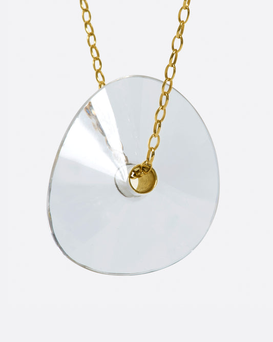 A yellow gold chain necklace with a large crystal quartz bead pendant.