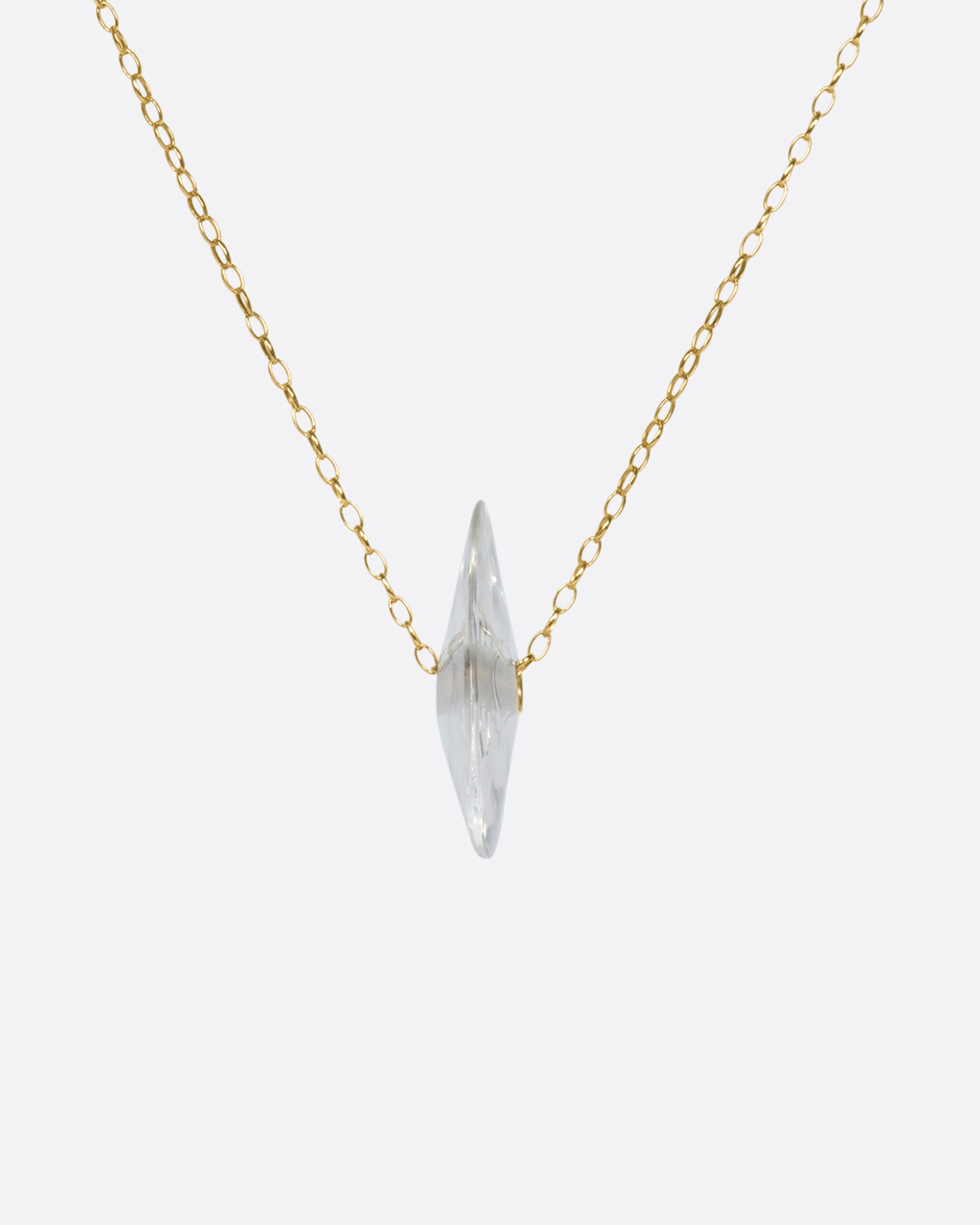 A yellow gold chain necklace with a large crystal quartz bead pendant.