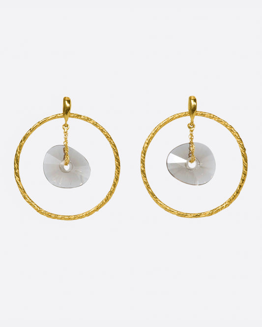 A pair of circular yellow gold wire earrings with smokey quartz donut-shaped beads hanging freely in the middle.