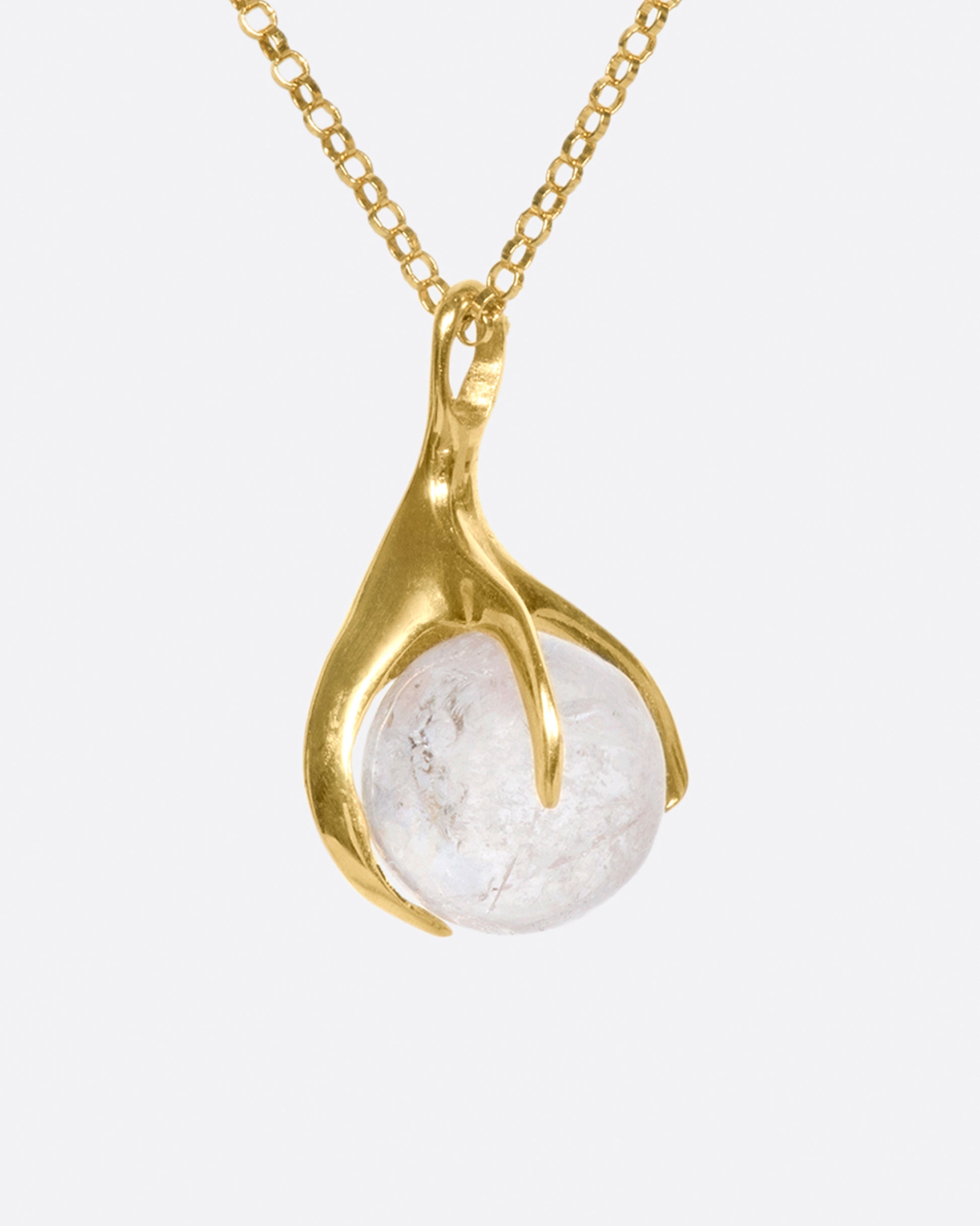 A pale pink tourmaline sphere is set in a gold claw setting for a substantial, yet airy pendant.