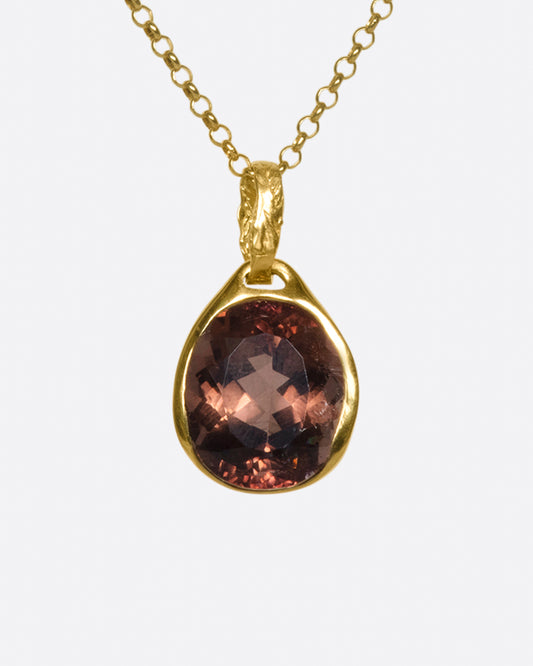 A faceted, reddish pink tourmaline pendant that can be worn facing either way to celebrate the glory of the stone.