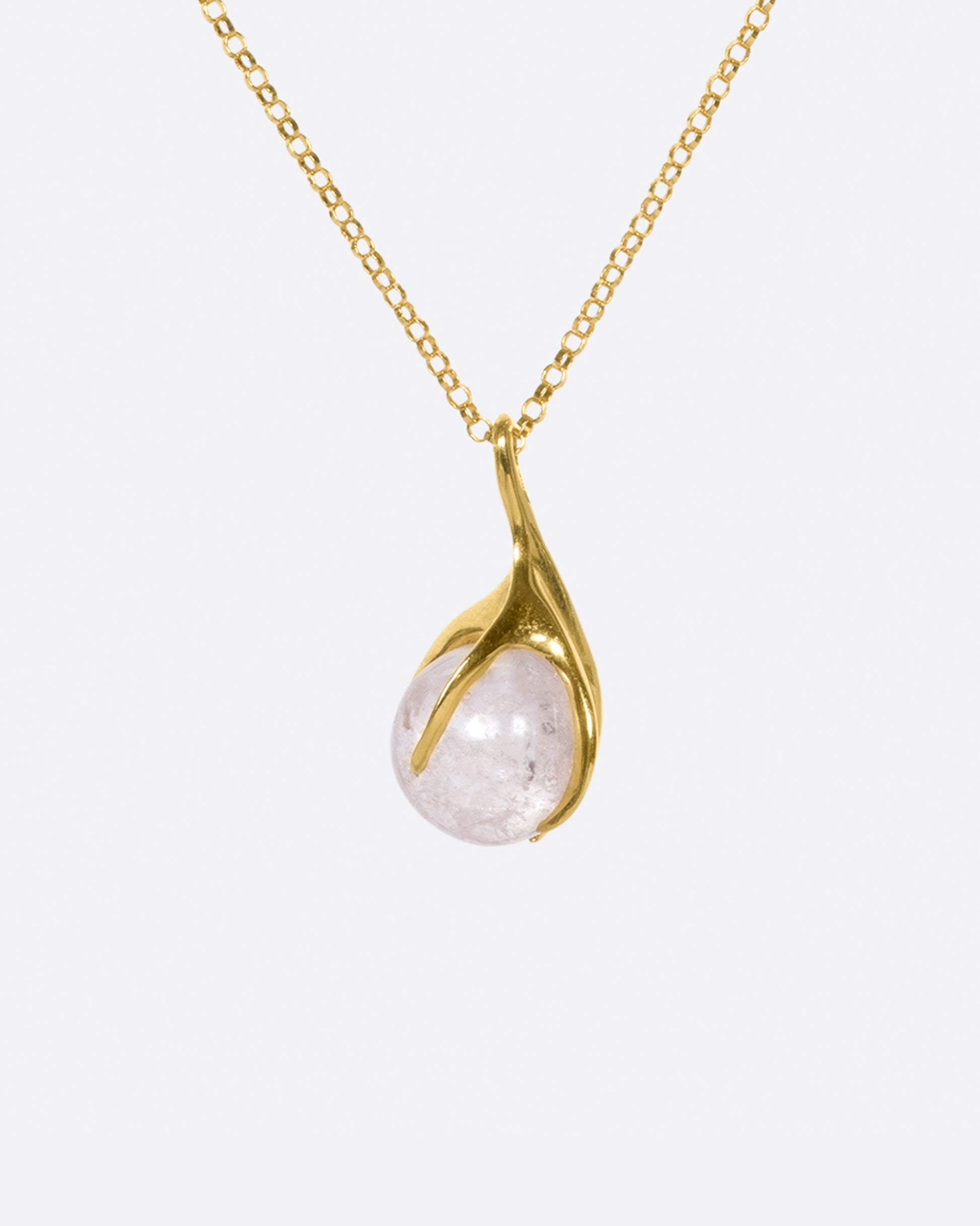 A pale pink tourmaline sphere is set in a gold claw setting for a substantial, yet airy pendant.