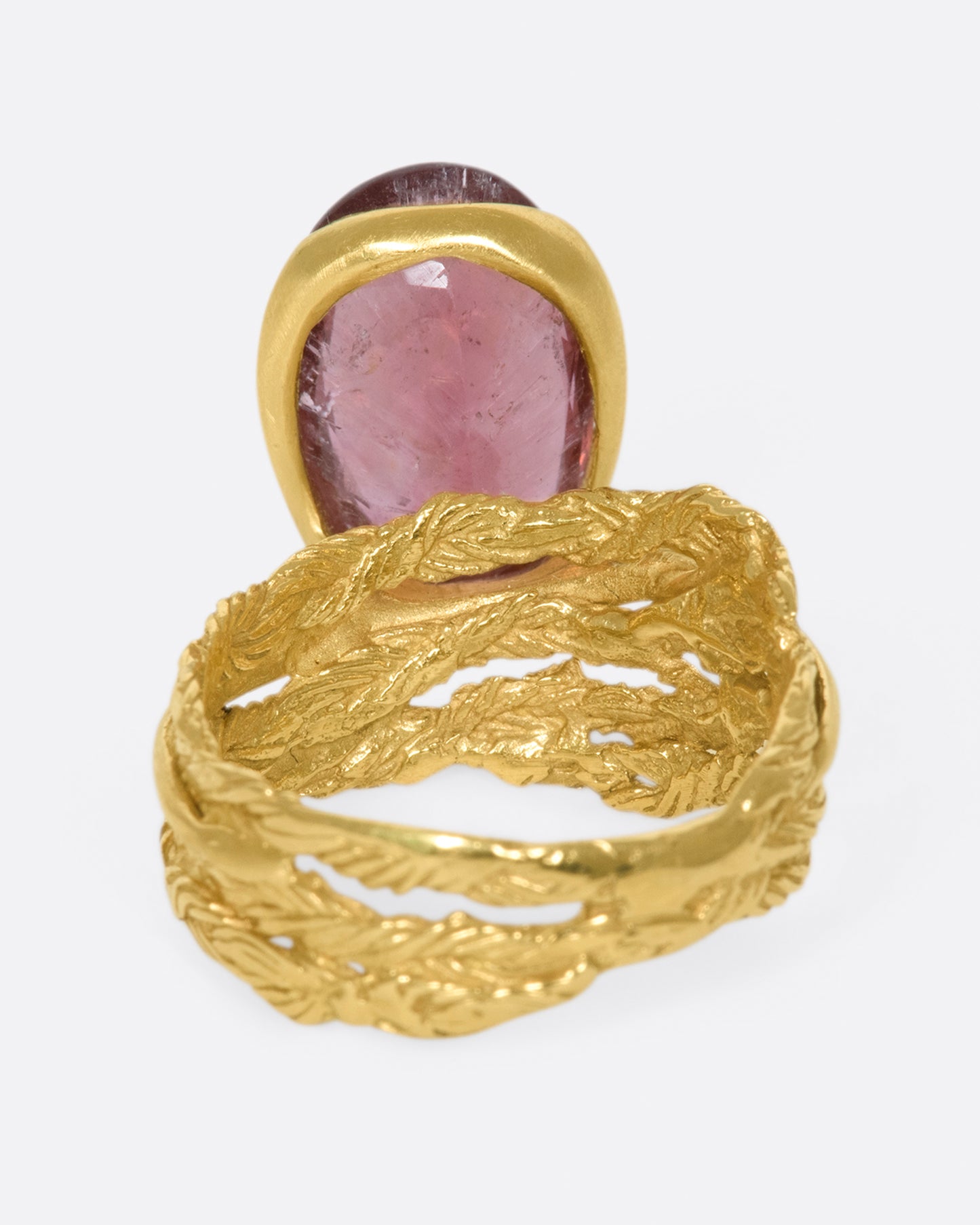 A gold braided band with an oval shaped rose tourmaline.