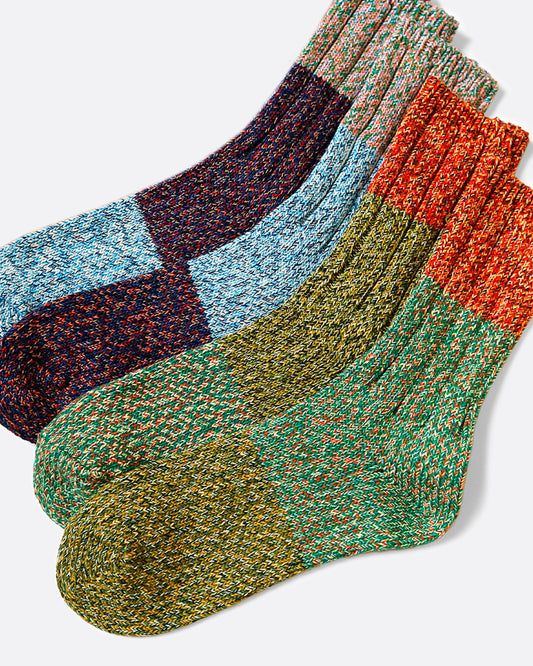 A pair of thick, loosely knit socks that are almost identical, but not quite.
