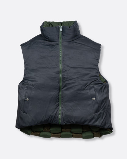 A green nylon padded vest woven in a traditional basket weave design. It has a reversible grey interior, a front zip closure, curved hemline, and internal snap welt hand pockets. Shown reversed from the front.