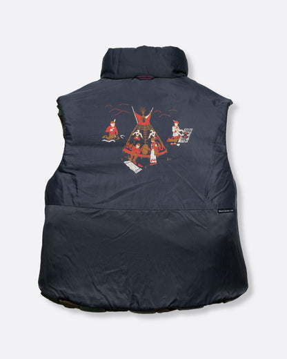 A green nylon padded vest woven in a traditional basket weave design. It has a reversible grey interior, a front zip closure, curved hemline, and internal snap welt hand pockets. Shown reversed from the back.