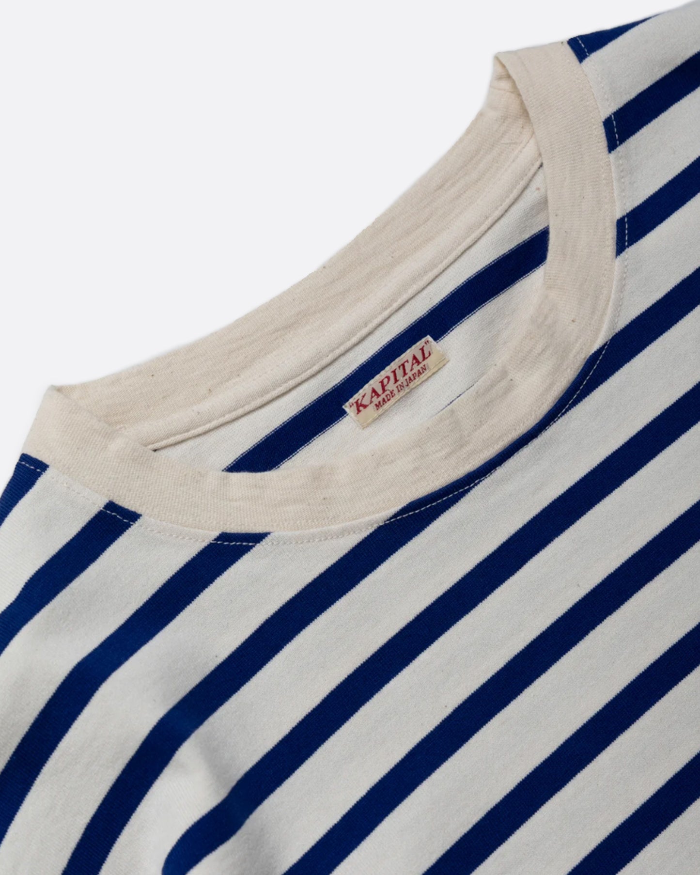 A blue and white striped, cotton, crewneck shirt with Kapital's fan favorite rainbow smiley elbow patches.