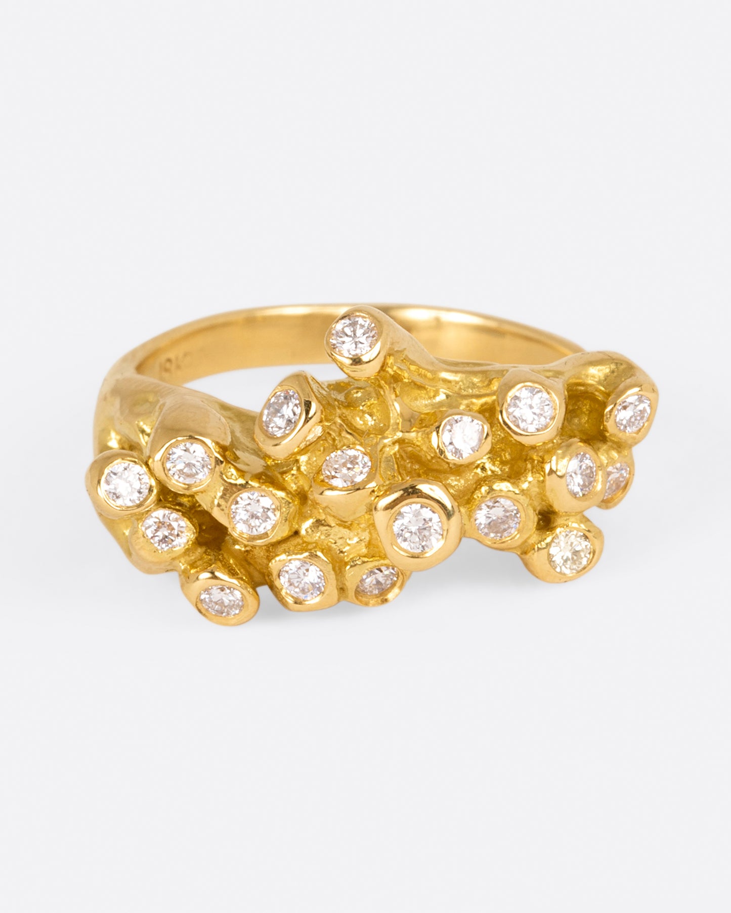 A yellow gold ring with sea anemone tentacles, dotted with diamonds, shown from front.