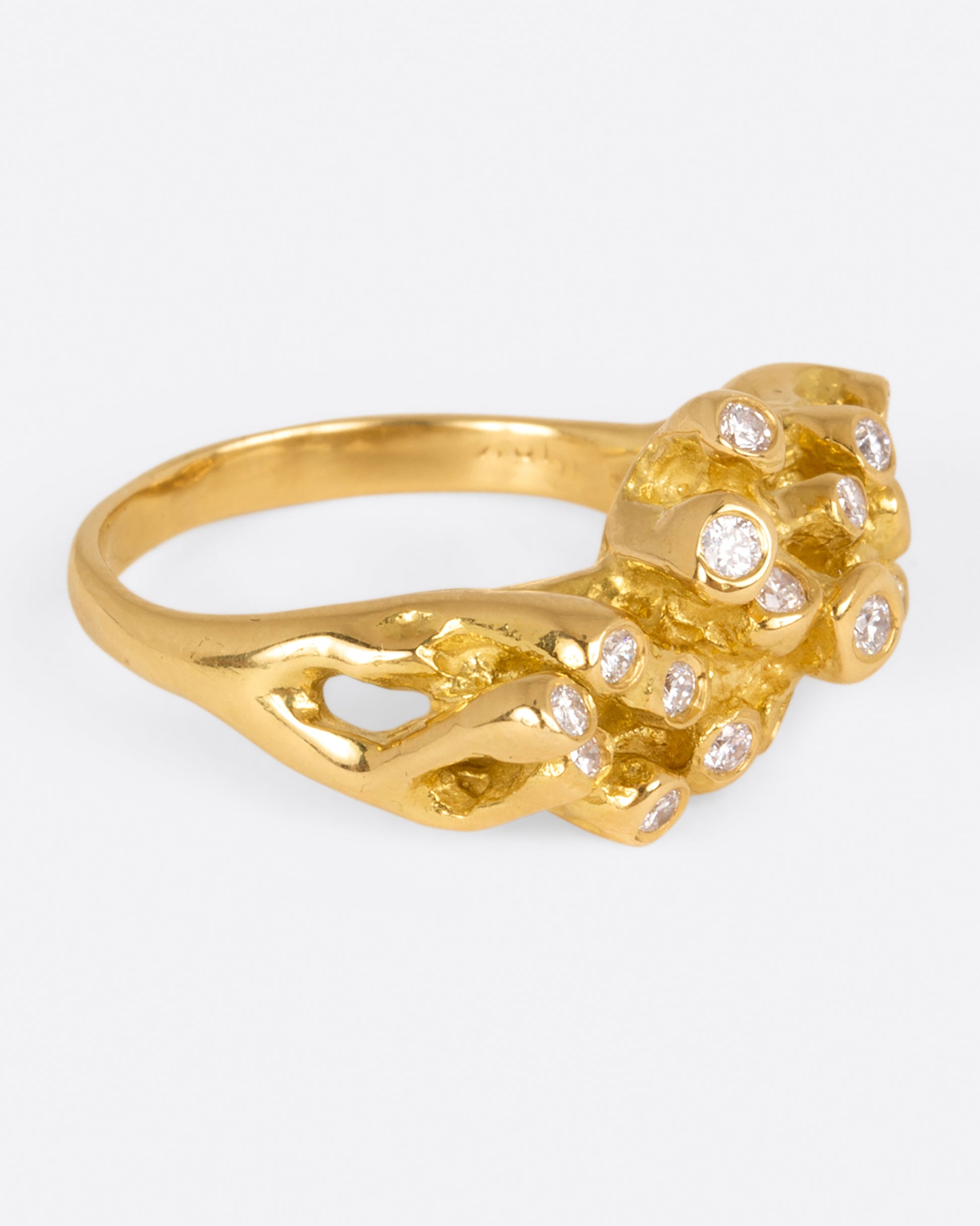 A yellow gold ring with sea anemone tentacles, dotted with diamonds, shown from side.