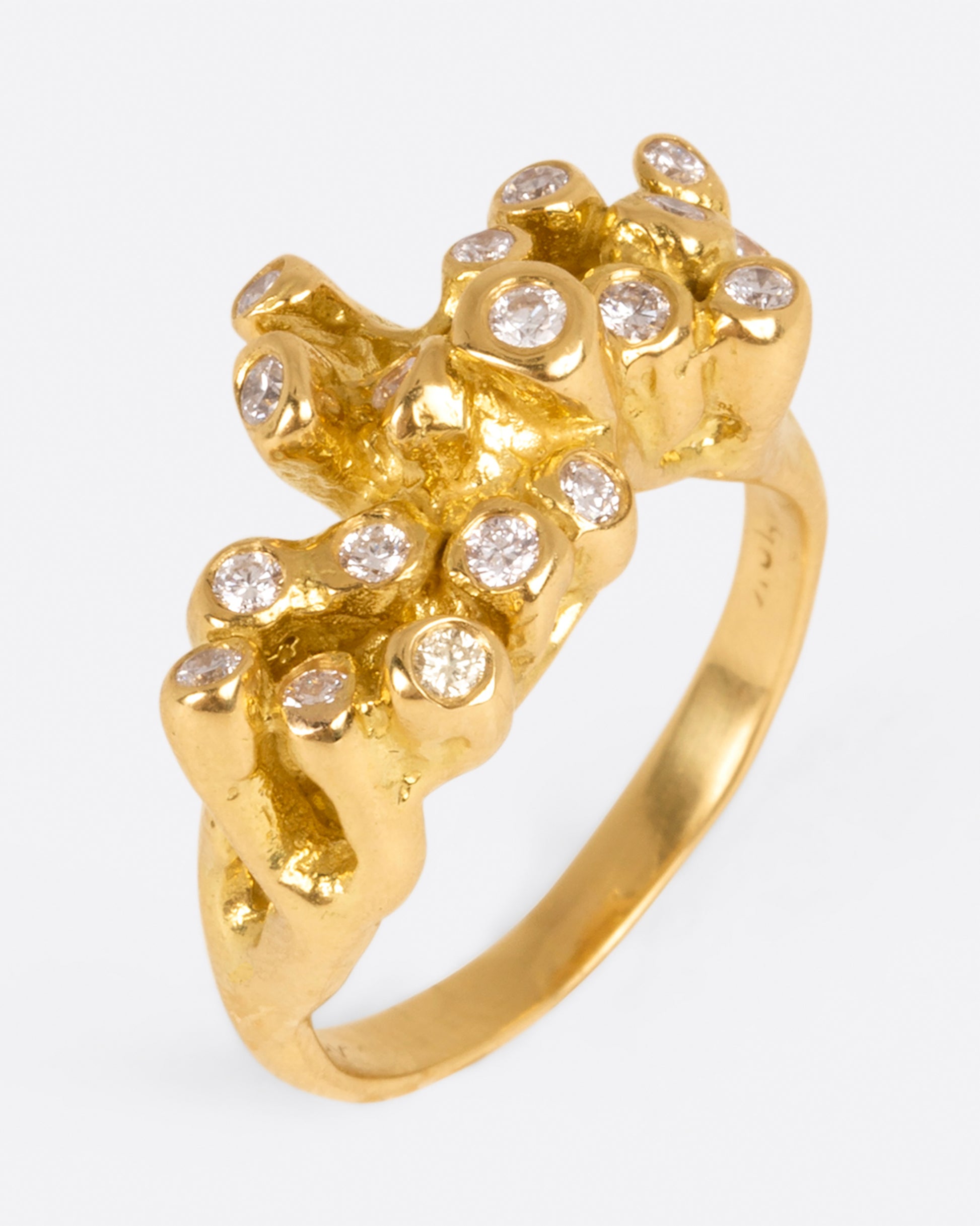 A yellow gold ring with sea anemone tentacles, dotted with diamonds, shown from above.