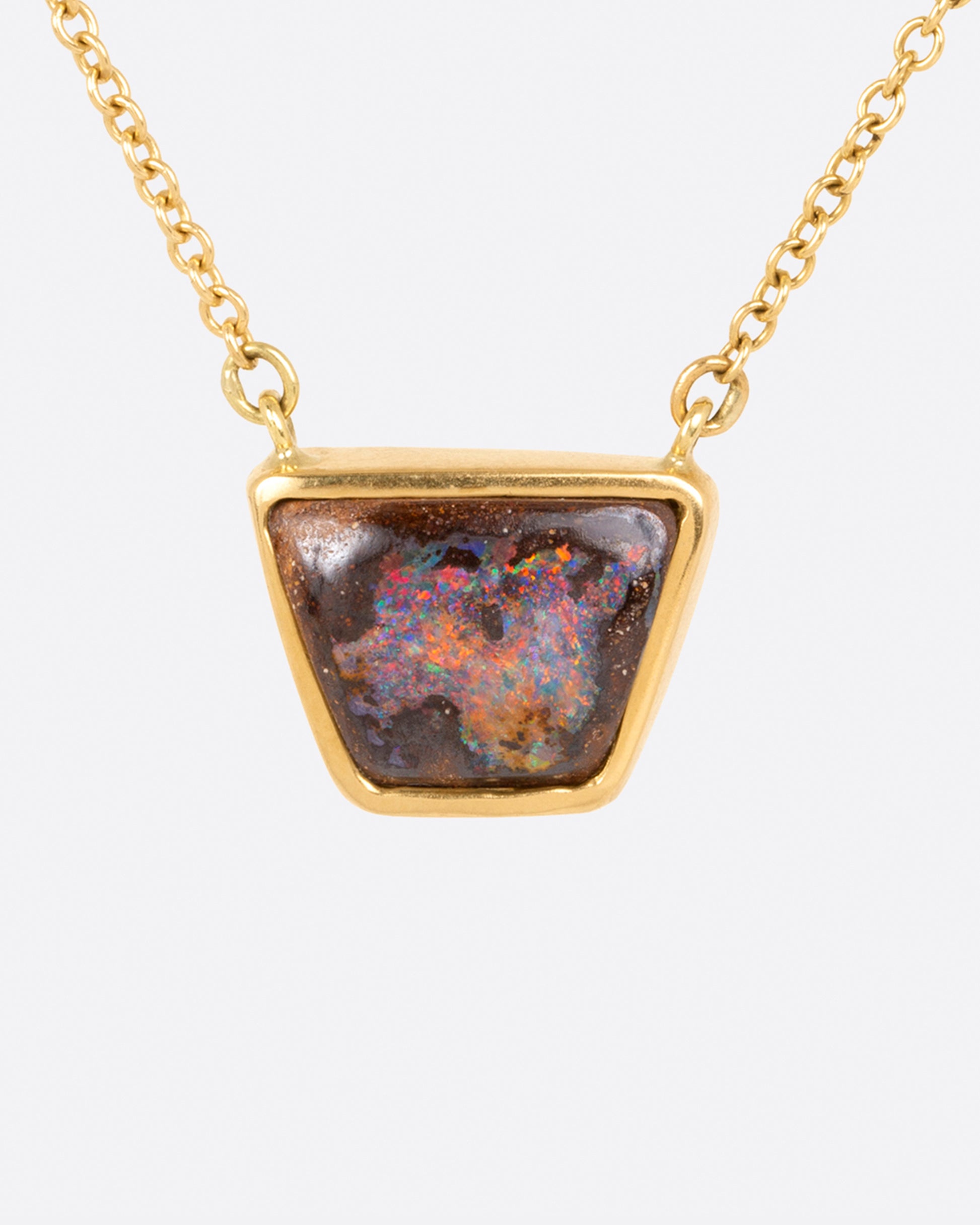 A flashy opalized wood is set in a simple bezel setting so the stone remains the star of this necklace.