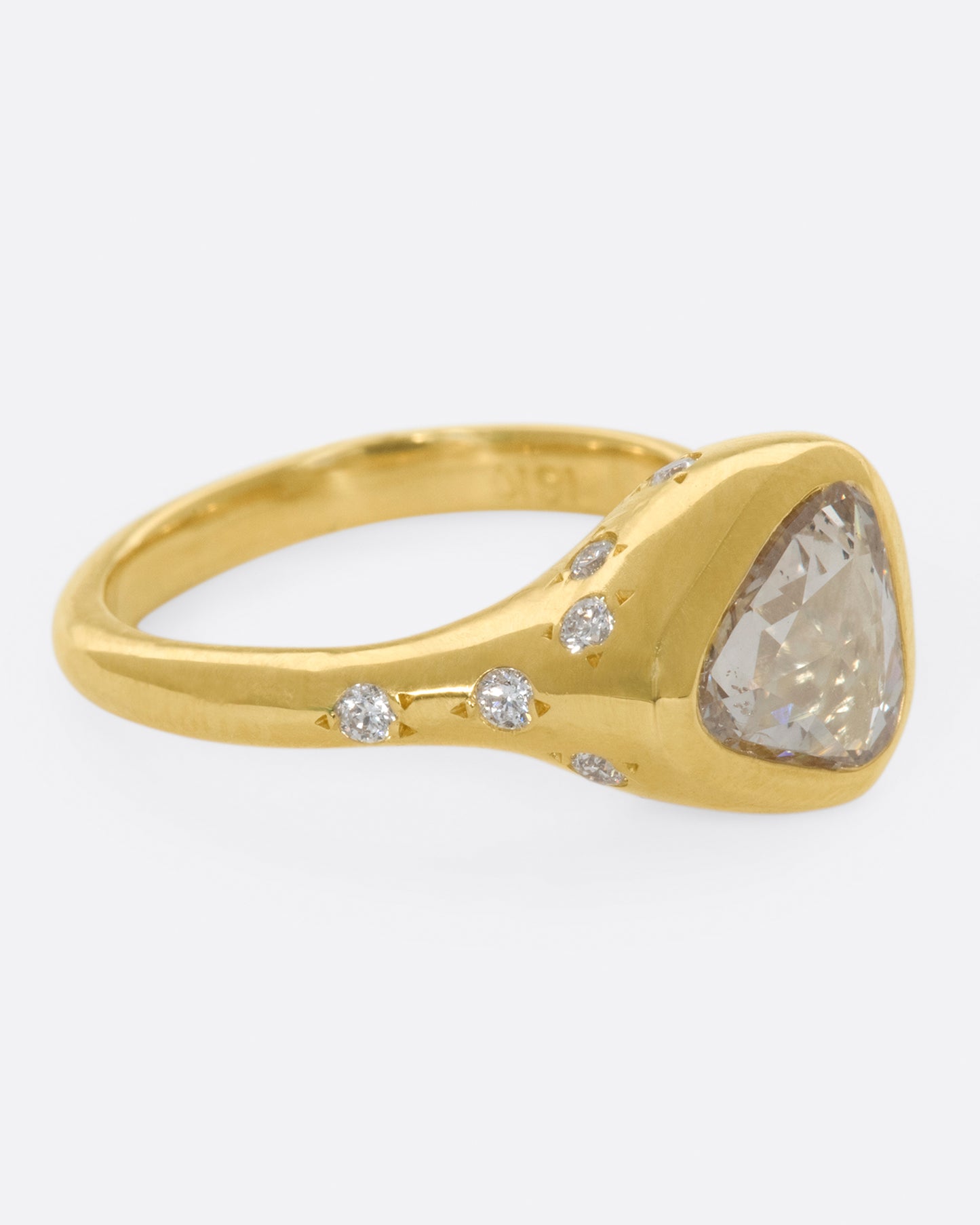 A glorious triangular, rose cut diamond sits on its side giving this ring an east-west sensibility.