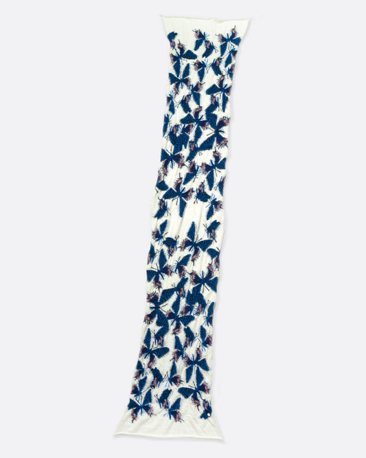 A white wool scarf covered in a flock of blue butterflies.