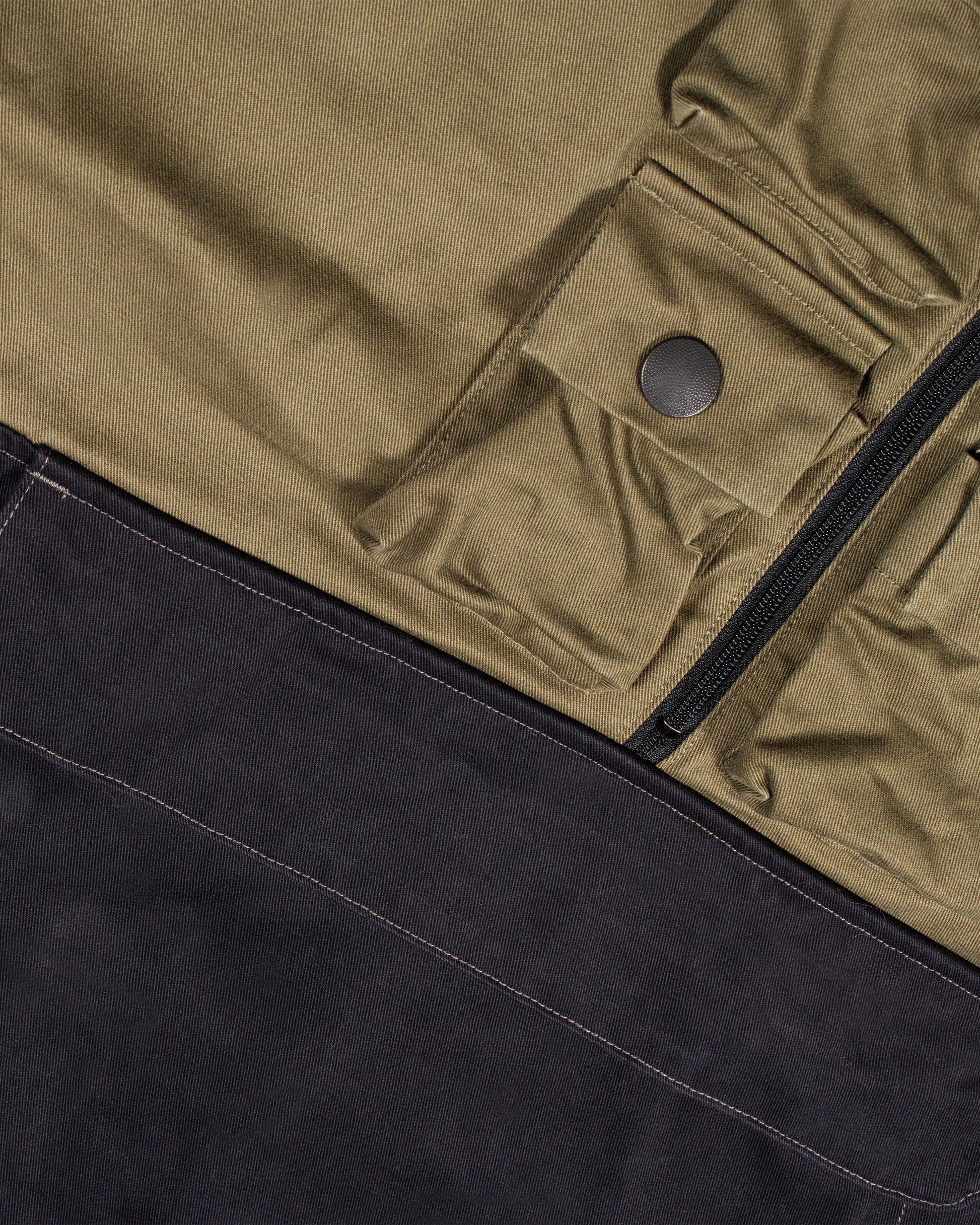 One of Kapital's beloved anoraks, made from two colors of cotton chino material with six mini pockets around the neck and a zip pocket with a flap on the front.