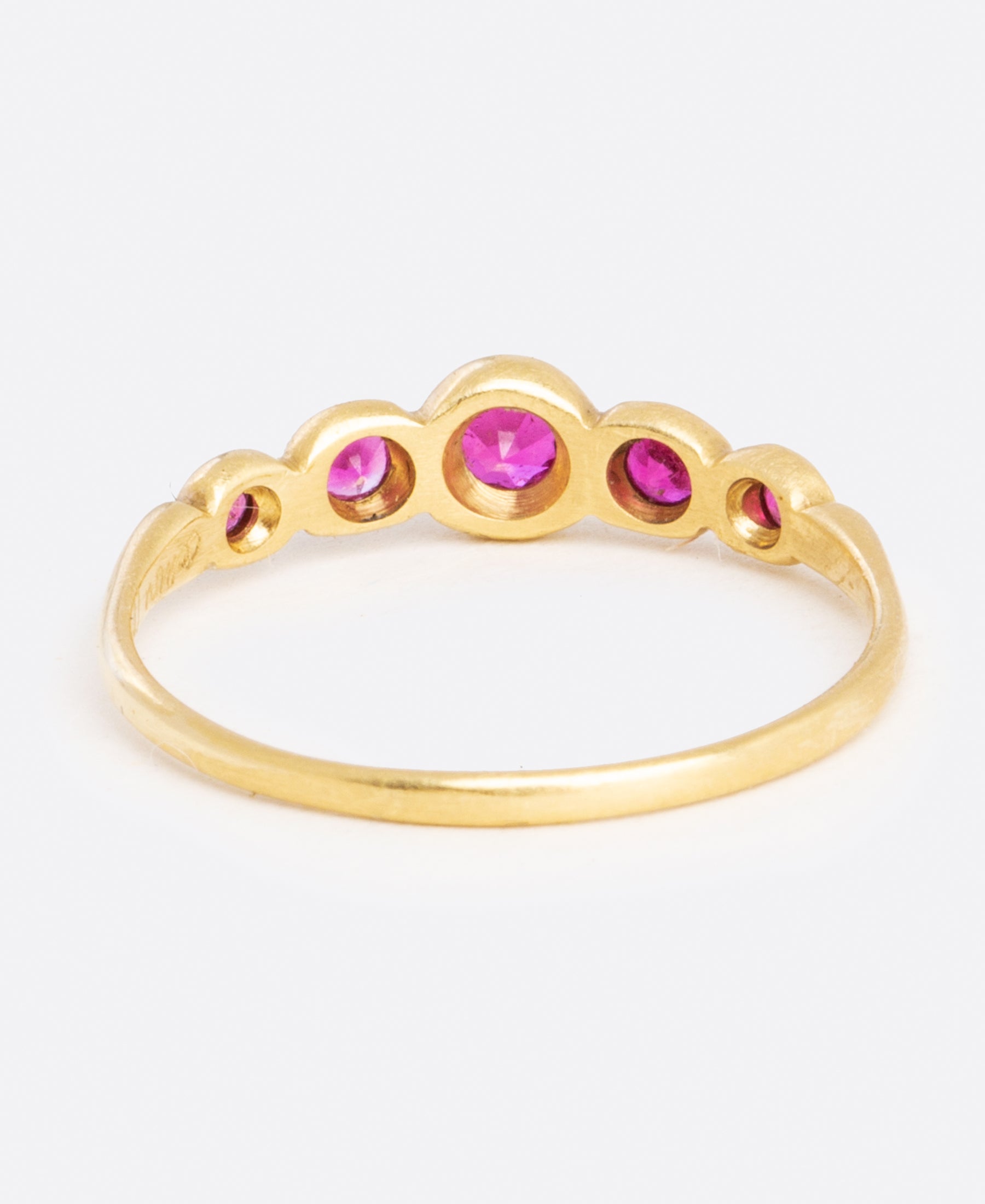 A classic combo, ruby and yellow gold, make up this ring with graduated sizes of stones.