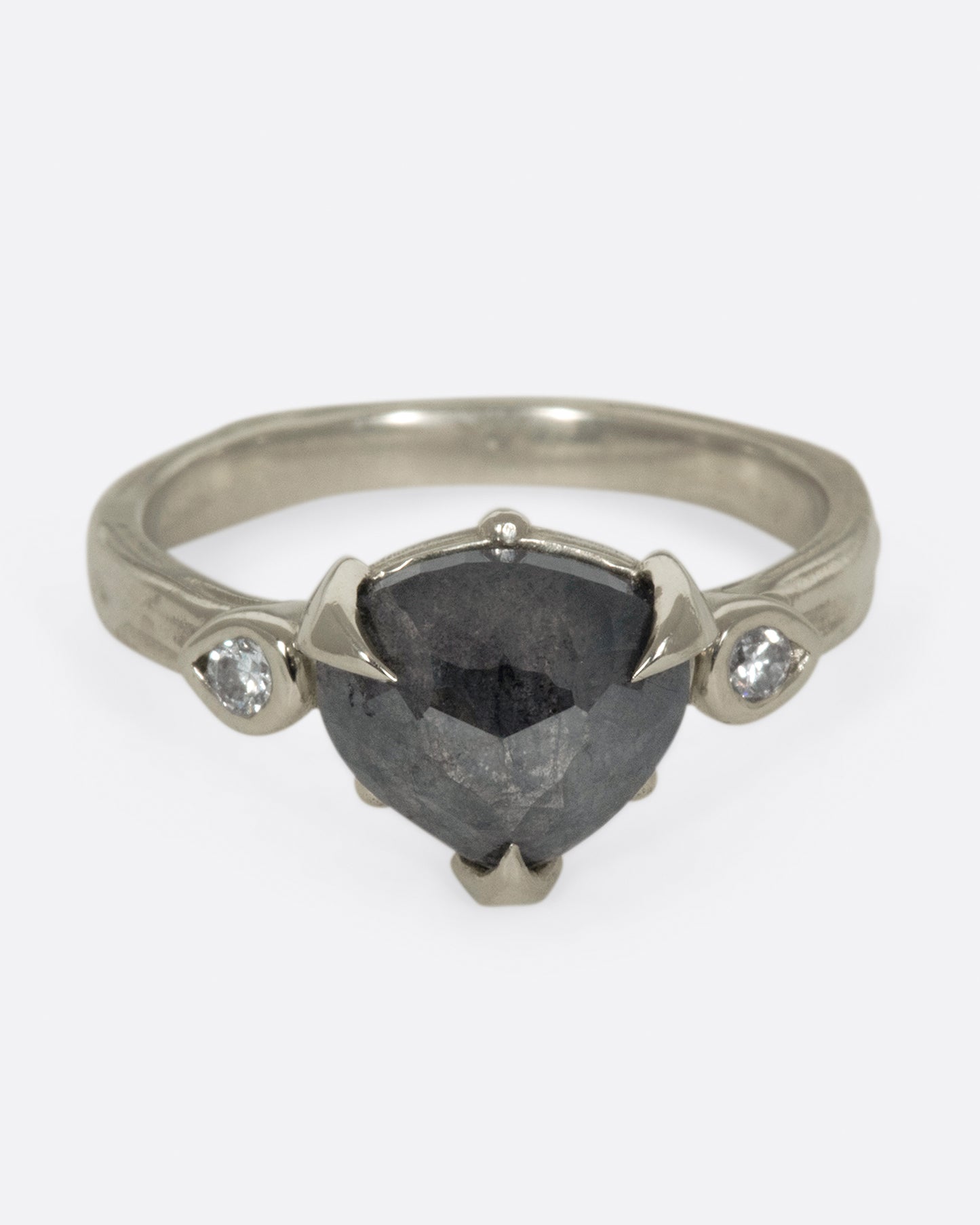 A dark, glamorous ring with a rose cut, heart-shaped diamond embraced in pointed claw settings.