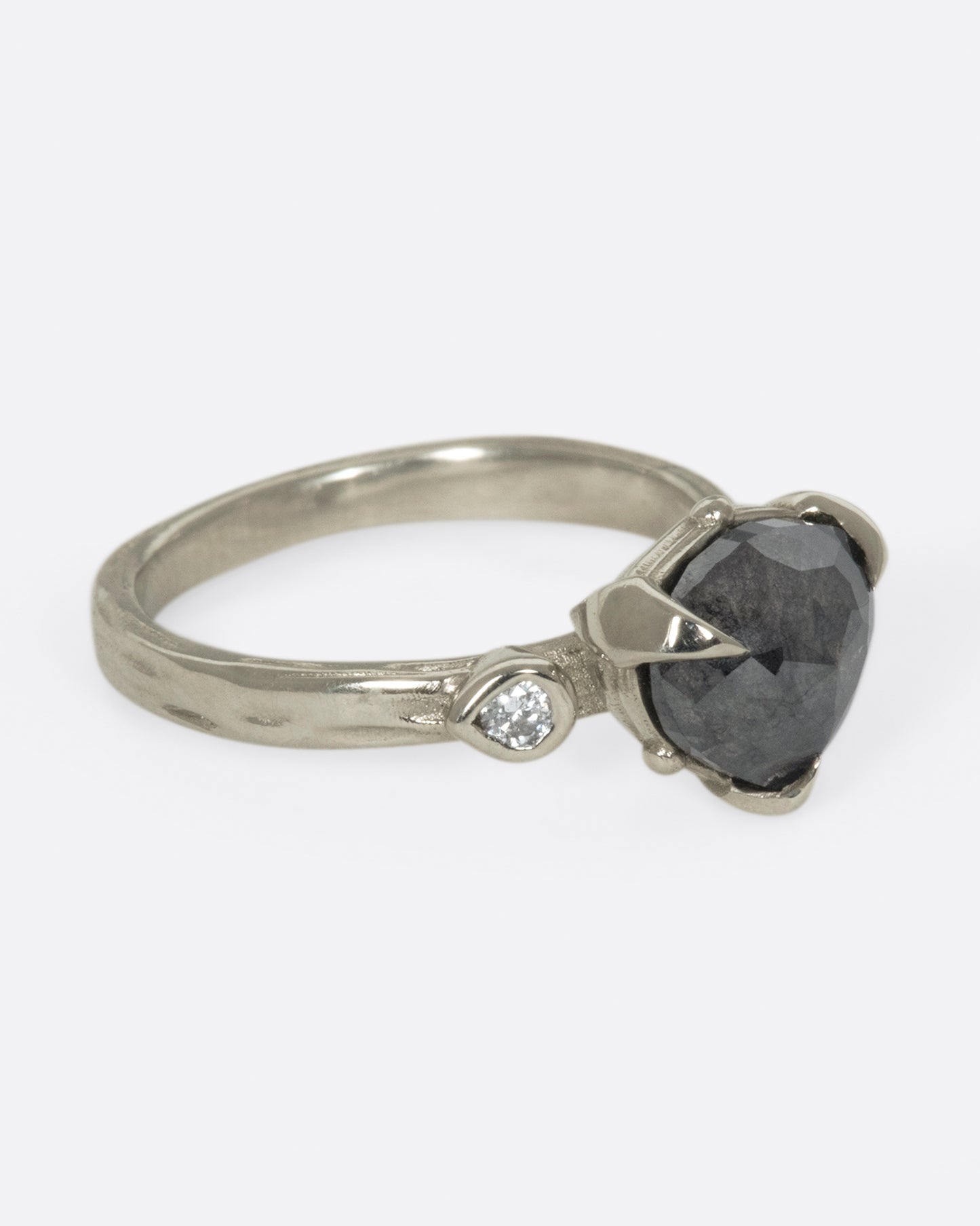 A dark, glamorous ring with a rose cut, heart-shaped diamond embraced in pointed claw settings.