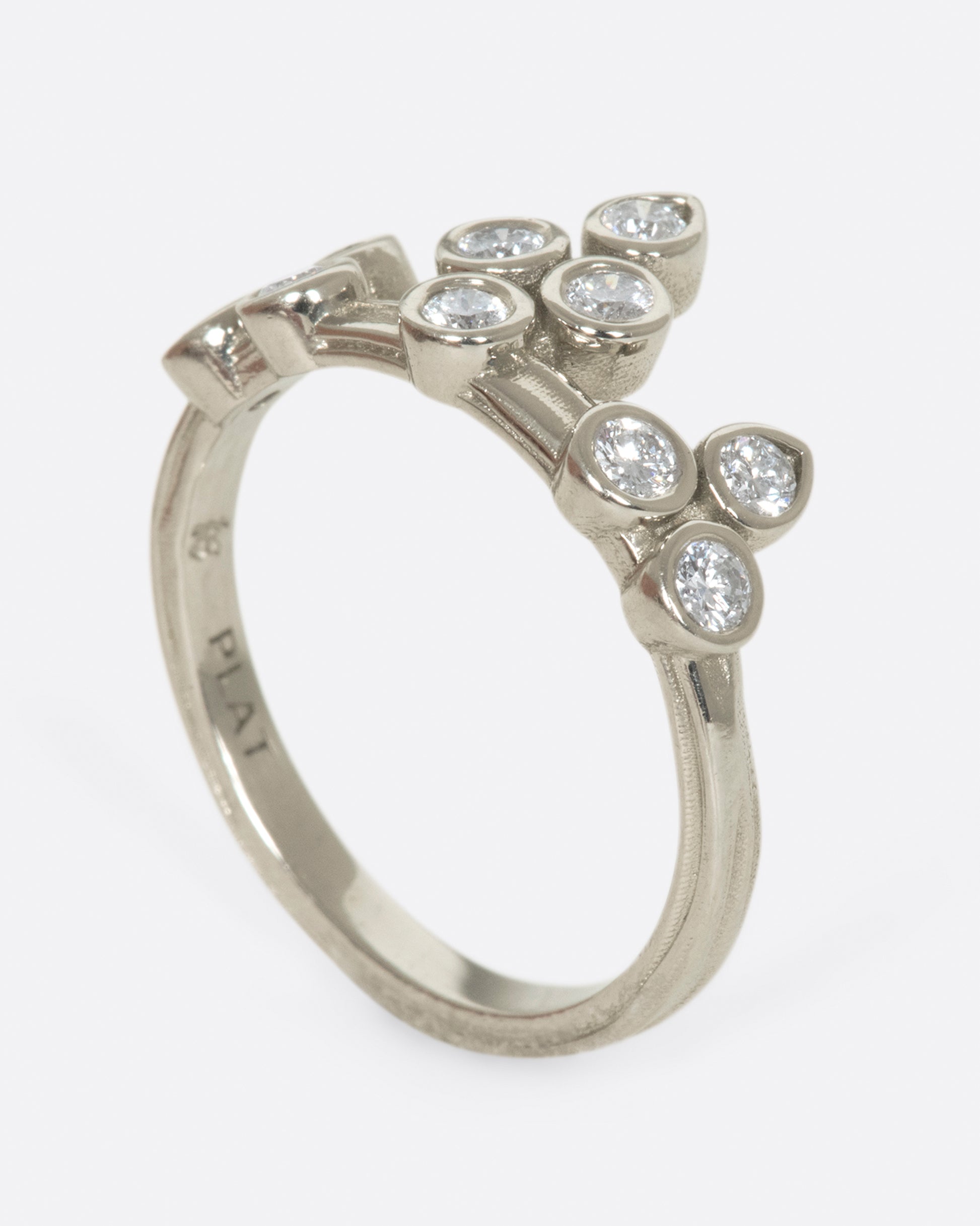 A tiara-like ring formed by 10 bezel-set round diamonds; wear it alone or stacked, and in either direction on the finger. 