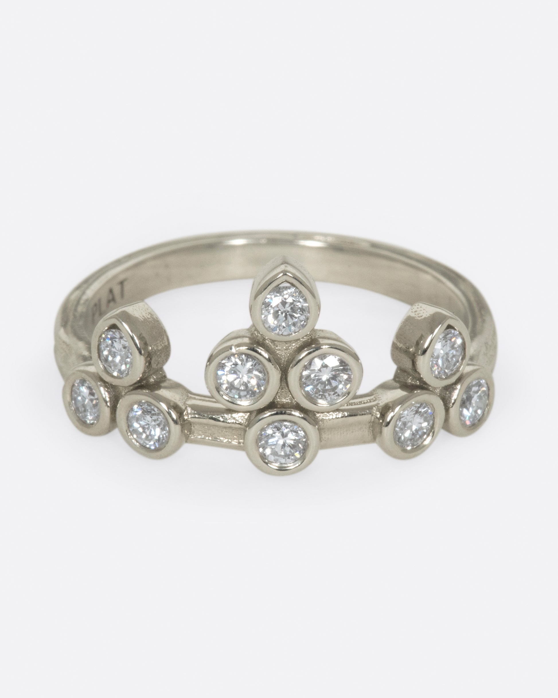 A tiara-like ring formed by 10 bezel-set round diamonds; wear it alone or stacked, and in either direction on the finger. 