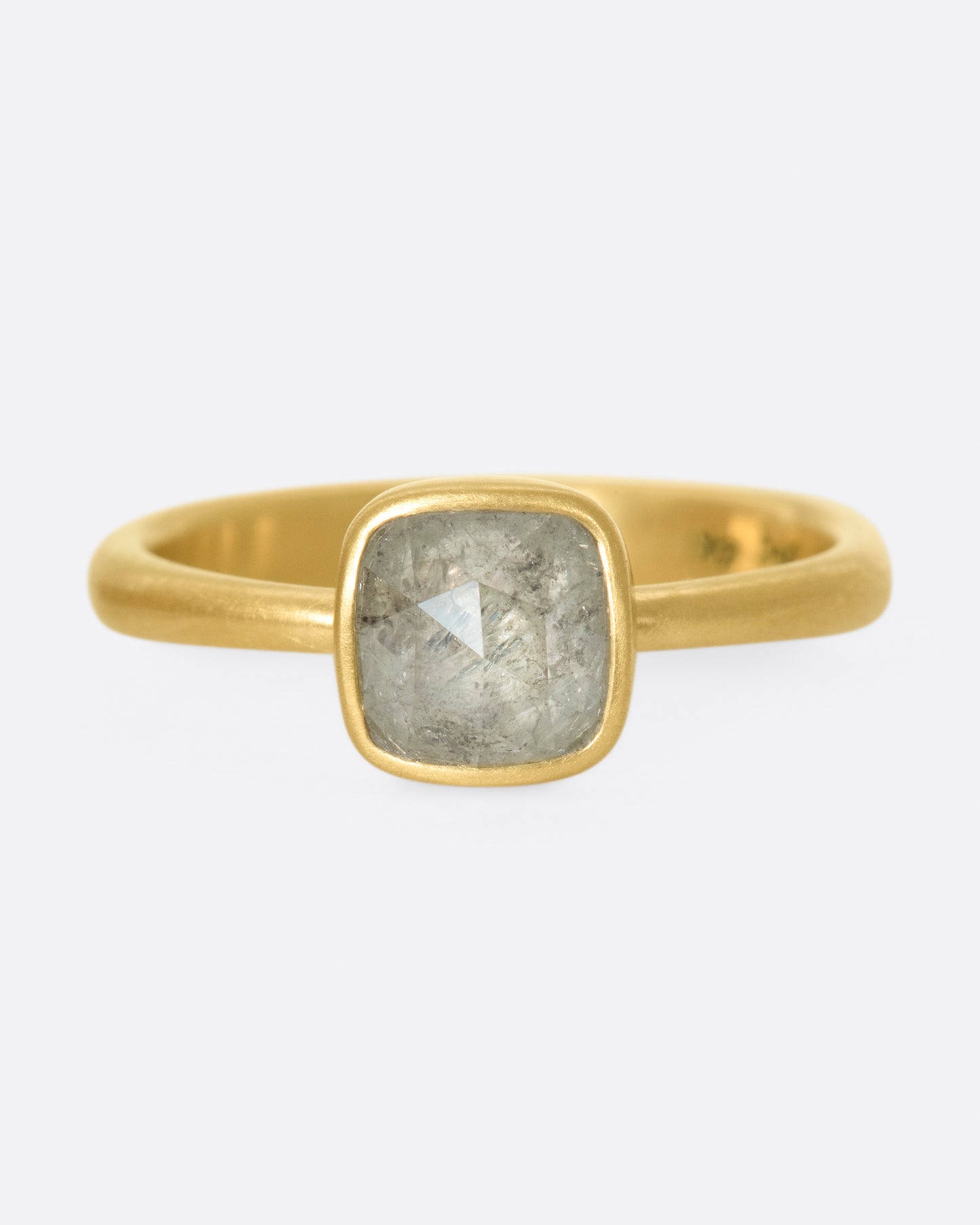 A faceted, cushion-shape diamond set in Lola Brooks' signature bezel setting