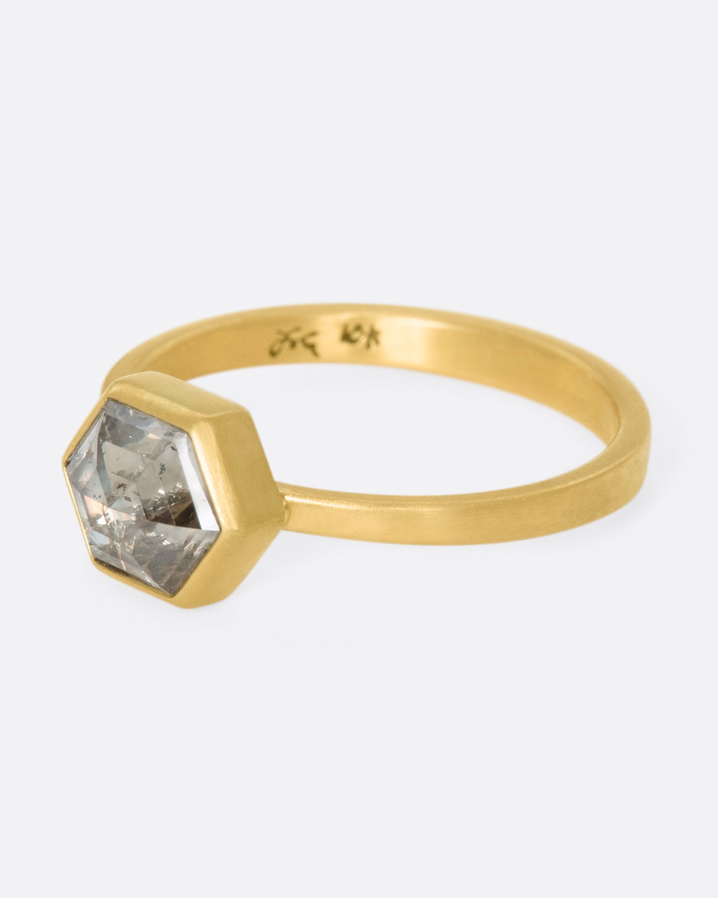 A hexagonal, faceted diamond whose colors range from shades of brown to gray