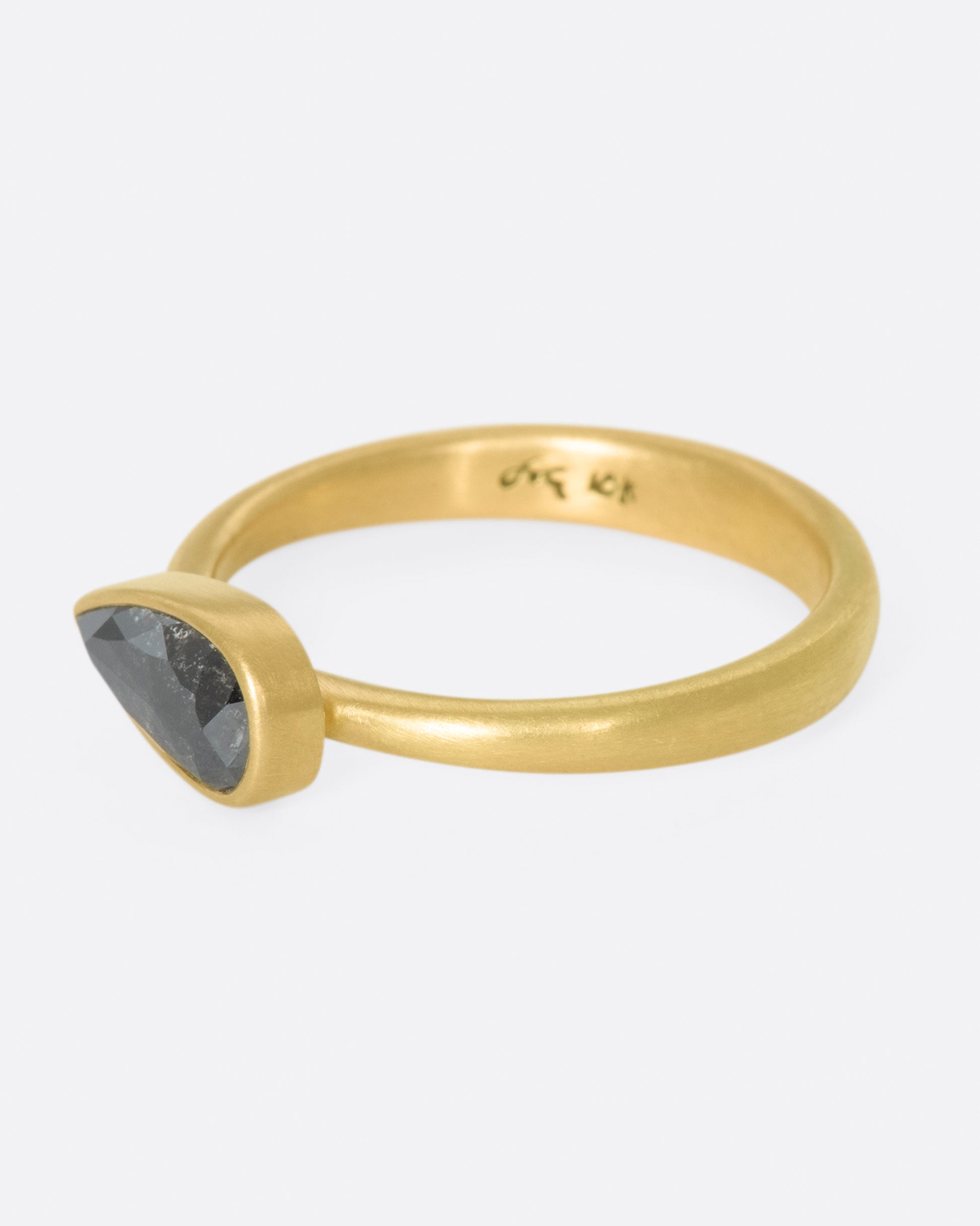 A solitaire ring with a dark, cloudy diamond set on its side